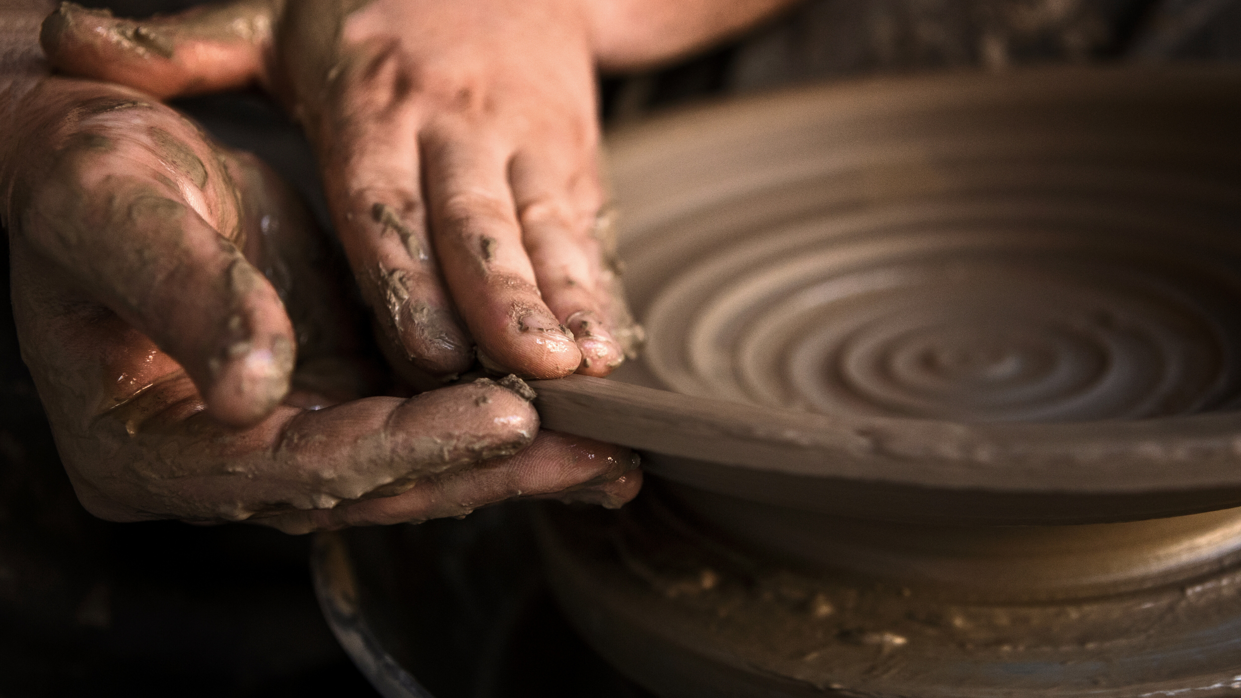 Artisan potter using their hands to shape a clay bowl