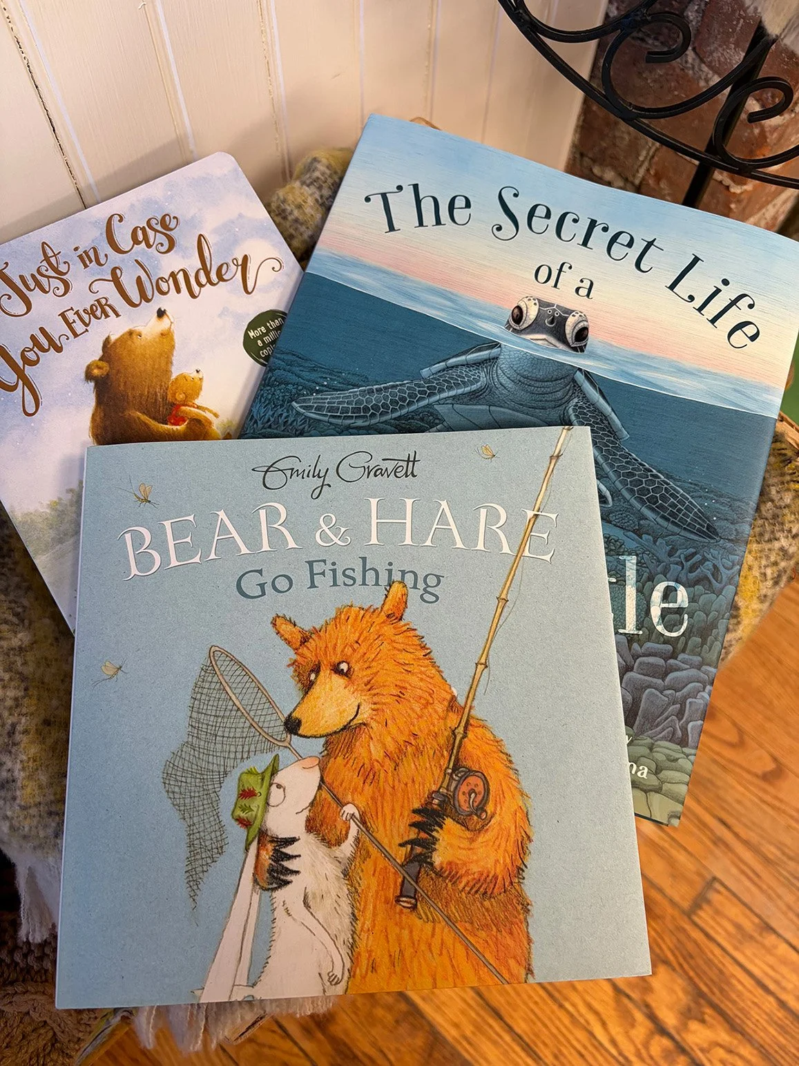 A book titled 'Encountering Angels' with a cover image of an angel and a woman in a red dress, a smaller booklet with a similar theme, and a deck of cards featuring angel imagery on a table near a black electronic device.