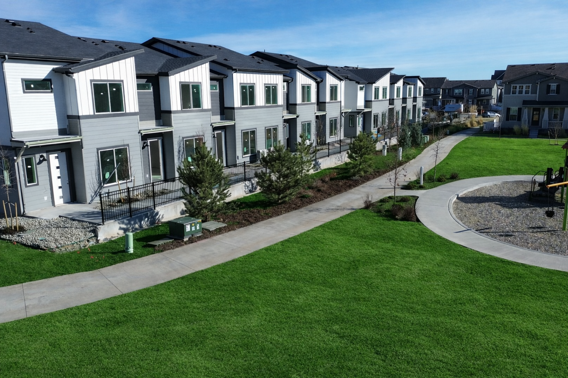 Suburban neighborhood with townhouses and playground.png