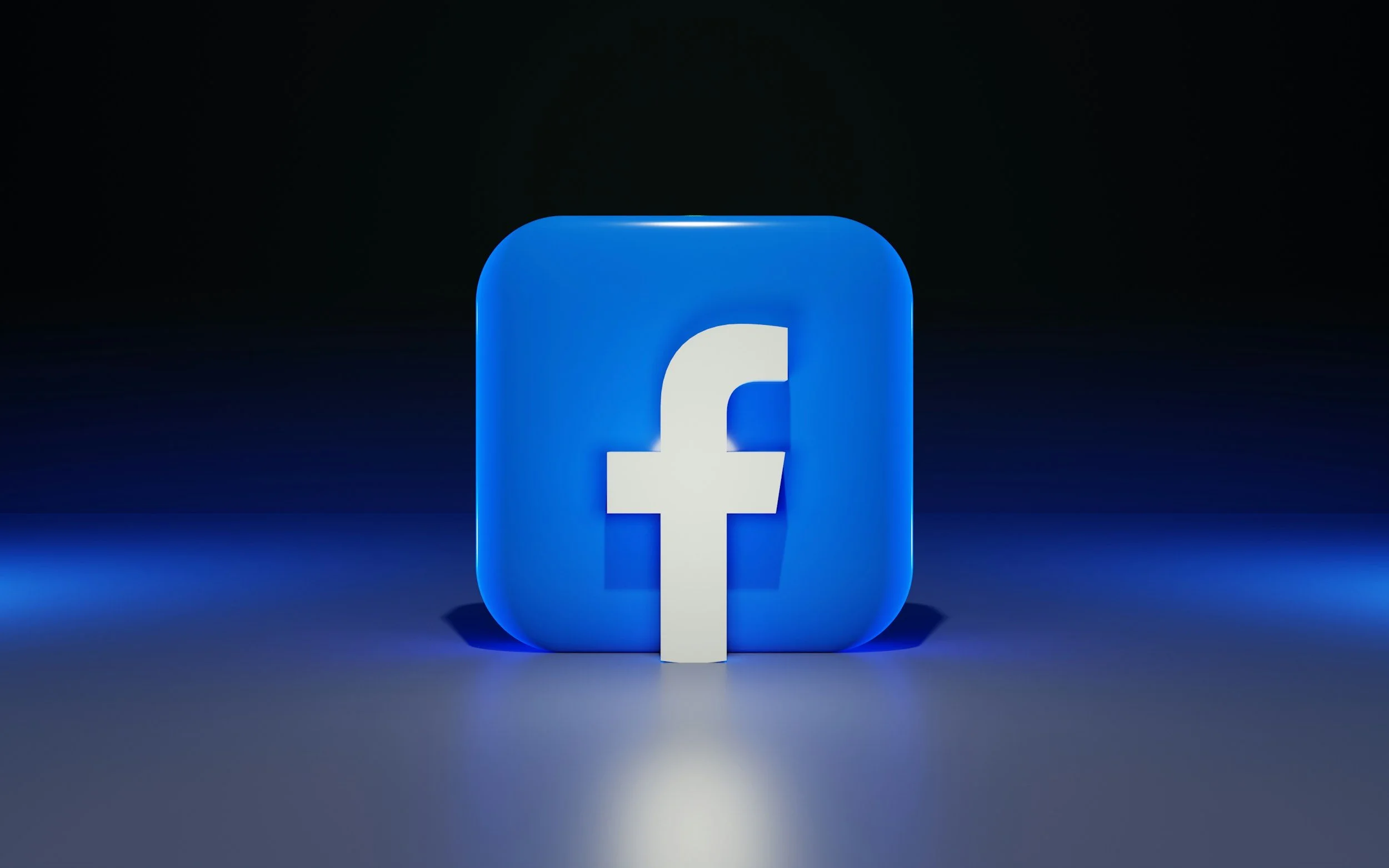 A 3D Facebook logo with a white 'f' on a blue rounded square, illuminated against a dark background.