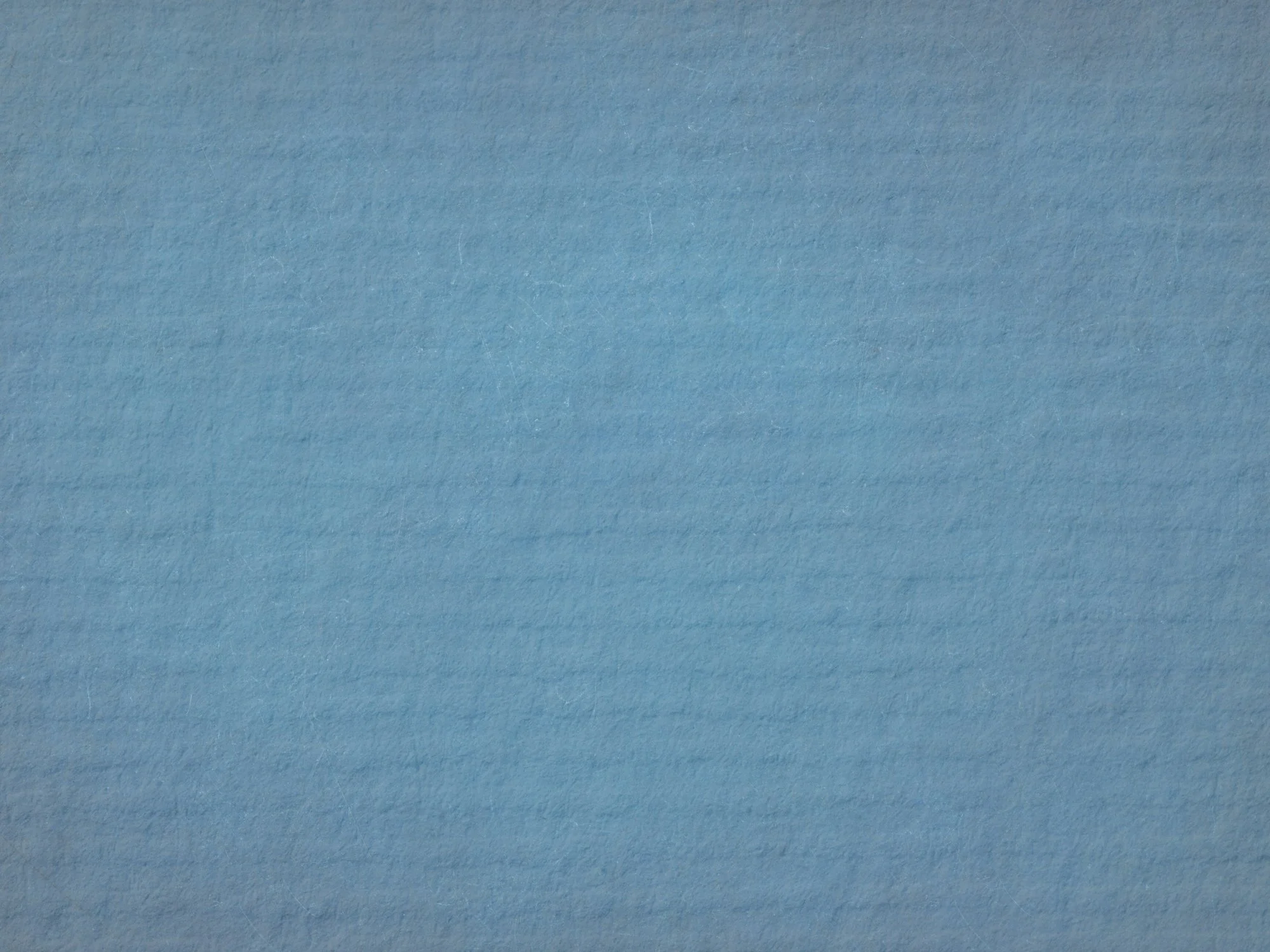 Close-up of a textured light blue paper or fabric surface.