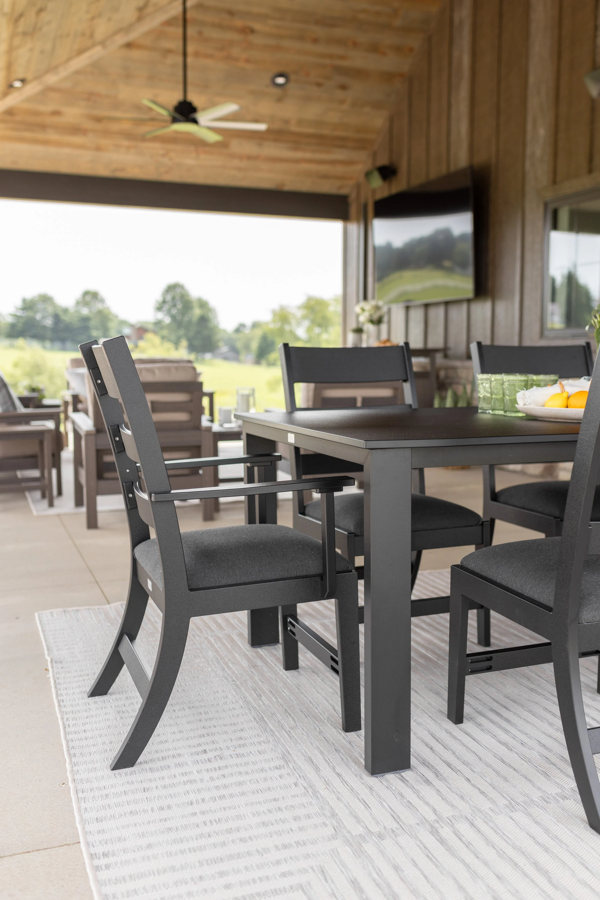 Parker Chair with arm kit in Matte Black with Heritage Char seat cushions. Paired with an 8’ x 11’ Finley Rug and Berkley Expandable Table.jpg