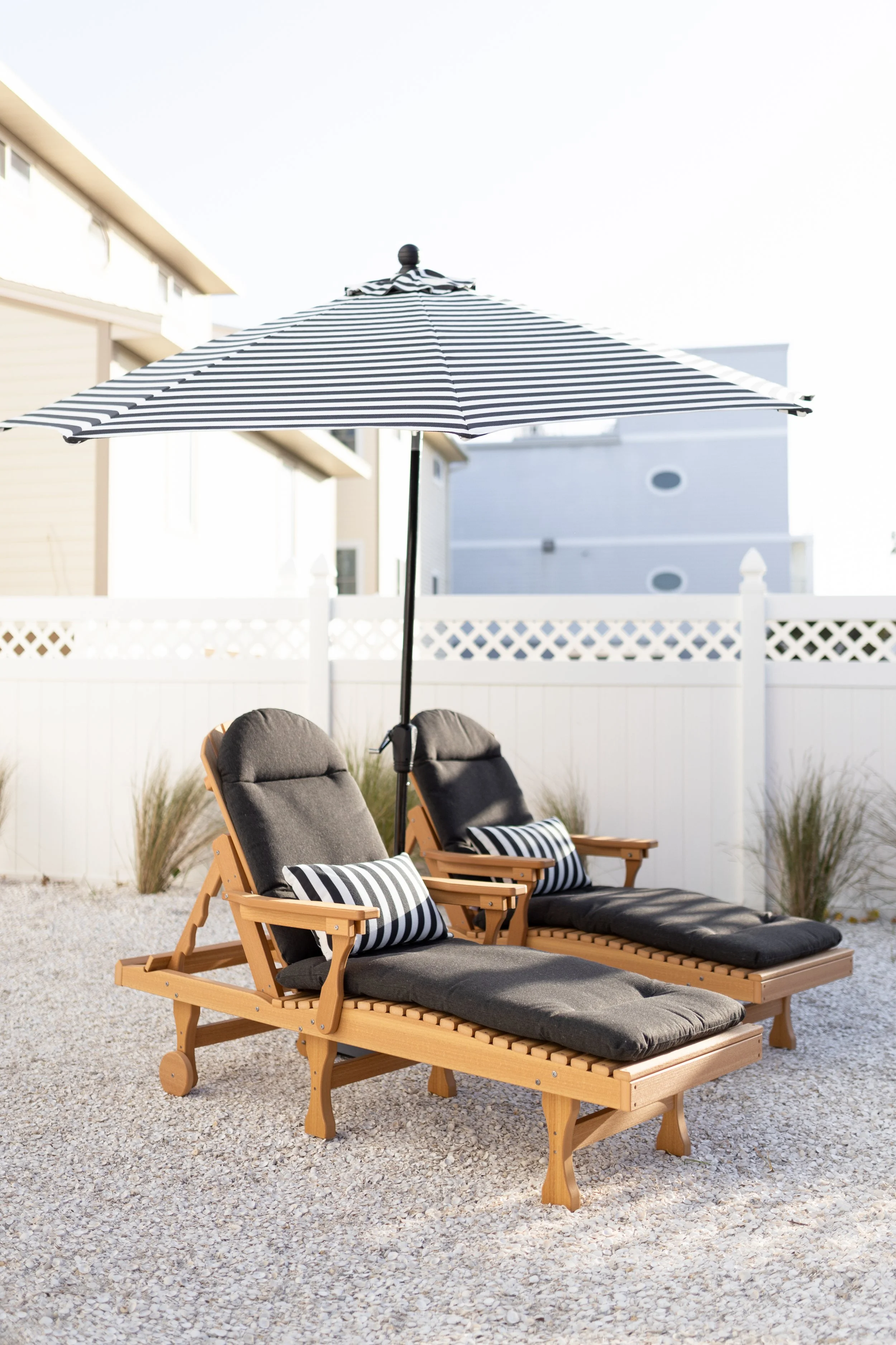 Comfo Back Chaise Lounges in Natural Teak. Cushions in Heritage Char. Pillows and Umbrella in Regatta Ebony.jpg