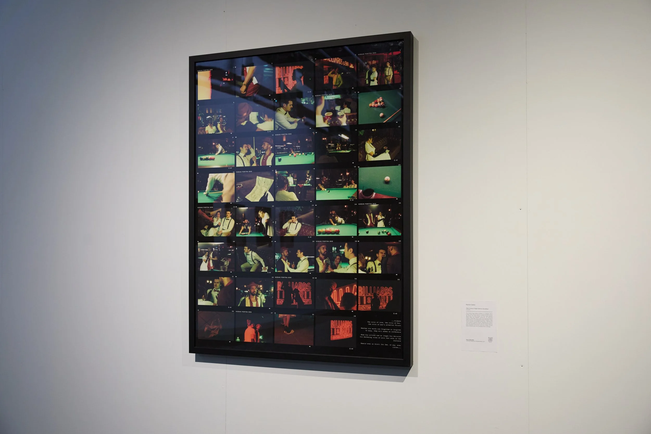 An installation photo of the framed contact sheet "The Crimson Night Before Goodbye on a white gallery wall.