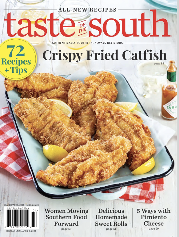 Crispy fried catfish fillets on a plate garnished with lemon wedges.