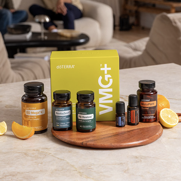 A collection of doTERRA essential oils and supplements displayed on a wooden board with lemon slices around them, on a marble countertop in a living room.