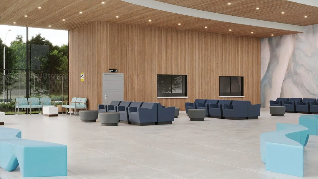 Interior of a modern waiting area with blue and gray seating, round gray ottomans, light blue curved chairs, a wooden wall, large windows showing outdoor greenery, and a patterned wall.