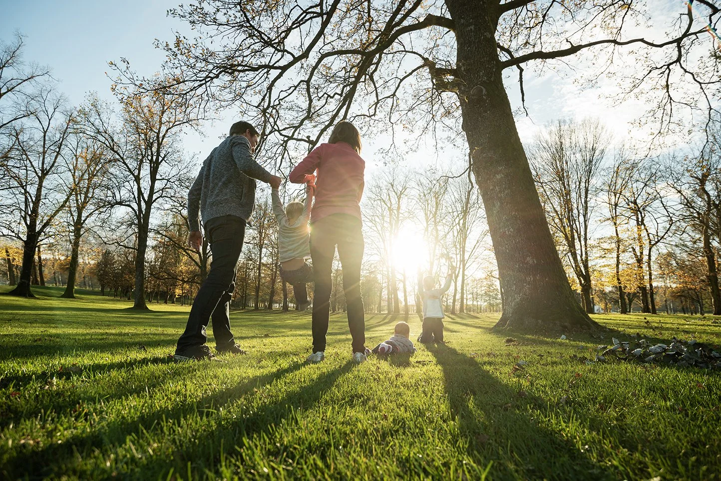 Parents playing with their 3 small children outside.