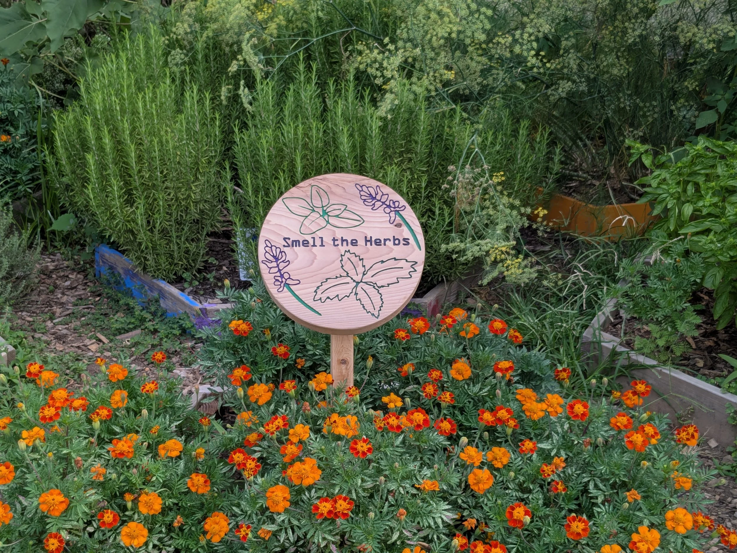 wooden garden exhibit sign with flowers