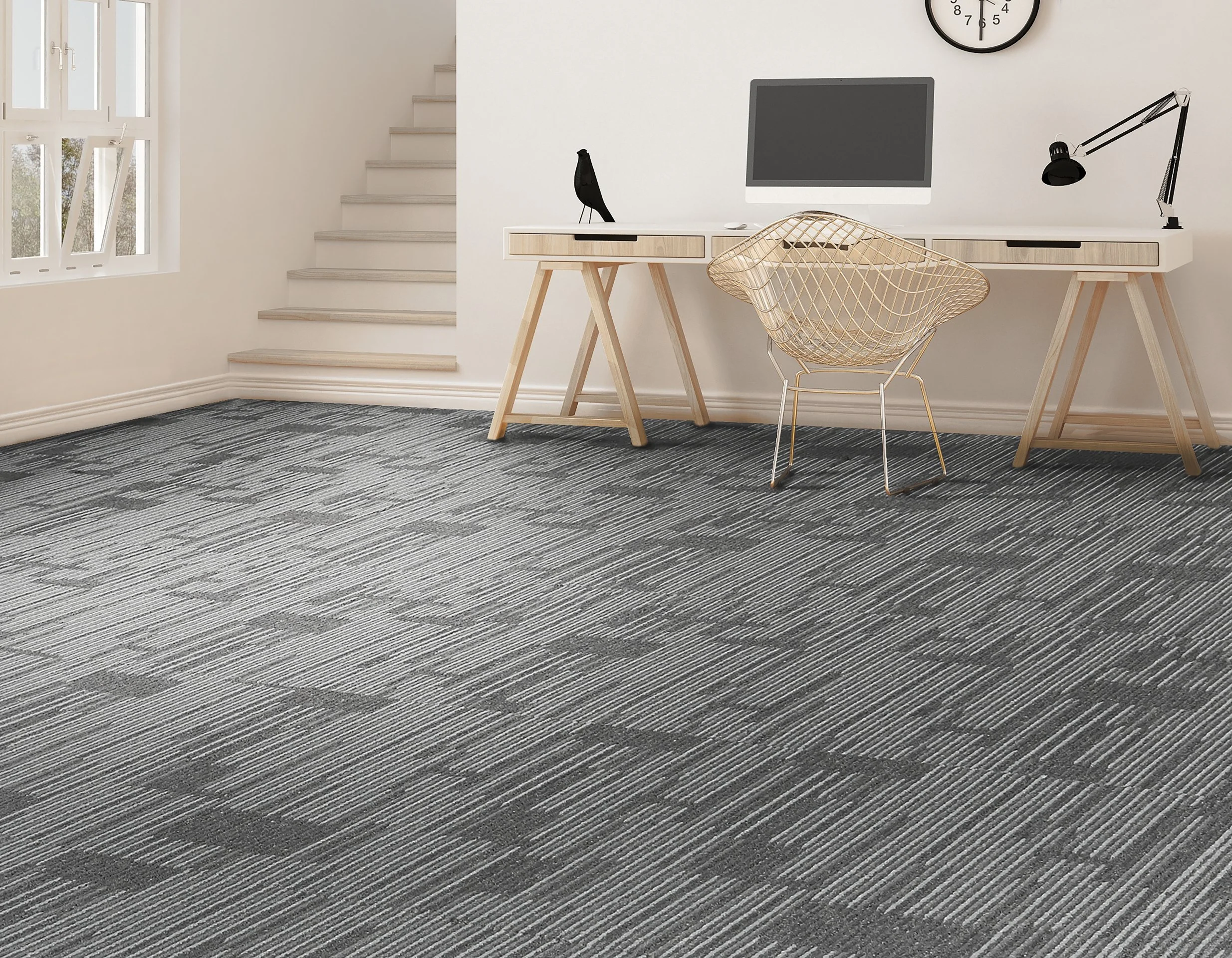 A modern, minimalist home office with a striped dark and gray carpet, a white desk, a gold wire chair, a black desk lamp, a computer monitor, and a clock on the wall.
