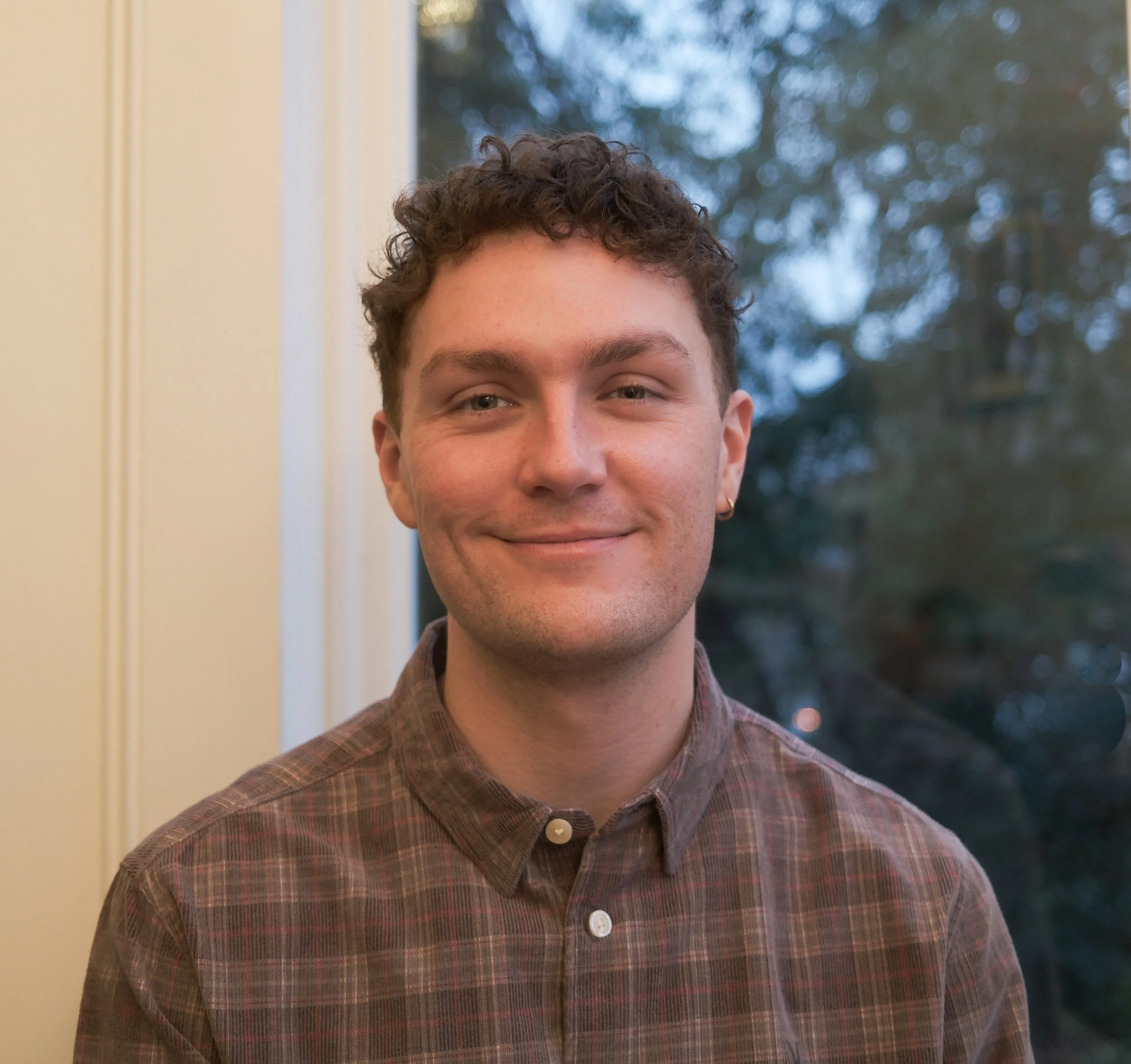 Headshot of a smiling GCSE and A-Level tutor offering online tuition to pupils seeking support in English Literature and/or English Language.