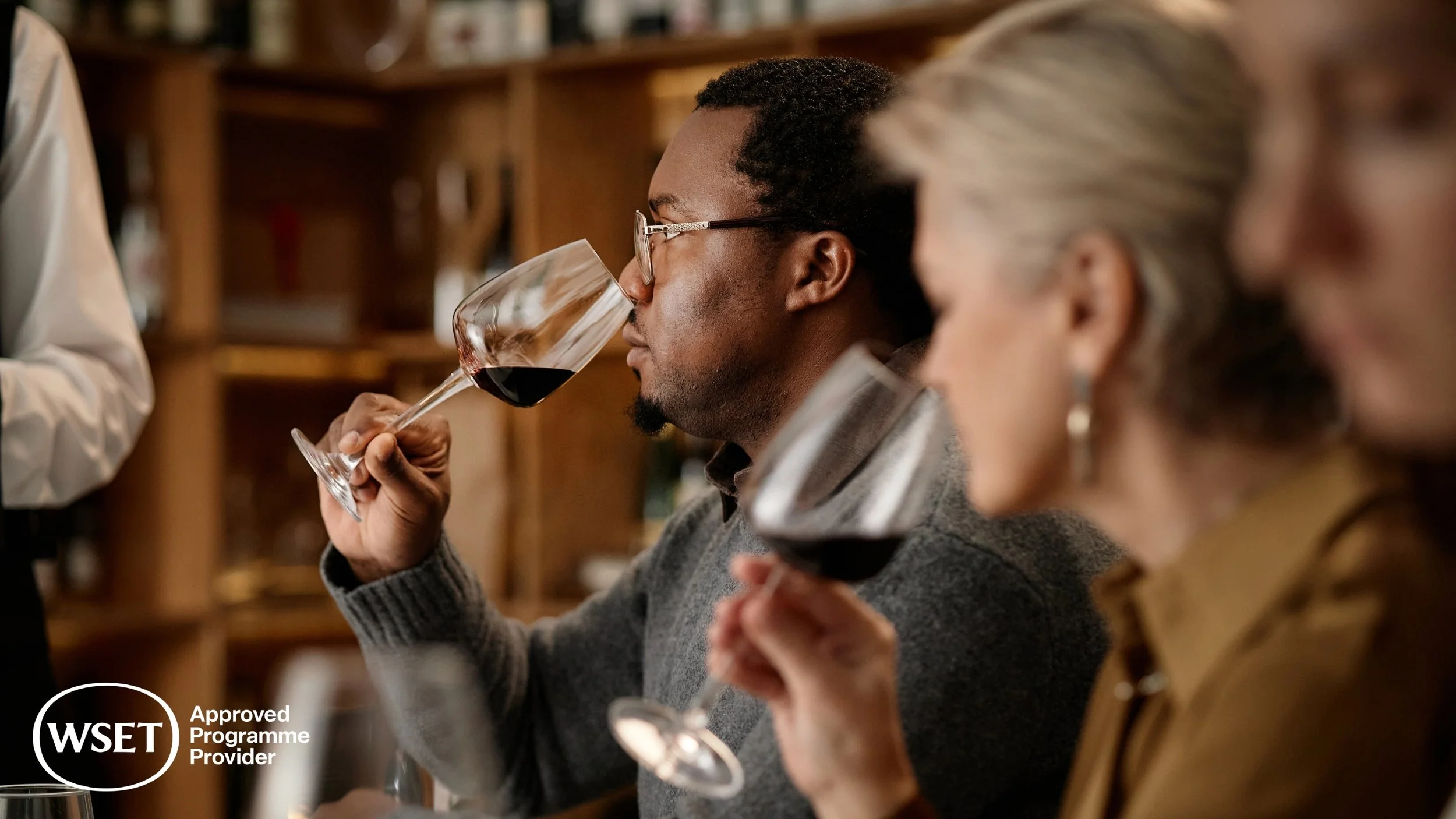 People tasting red wine at a tasting event.