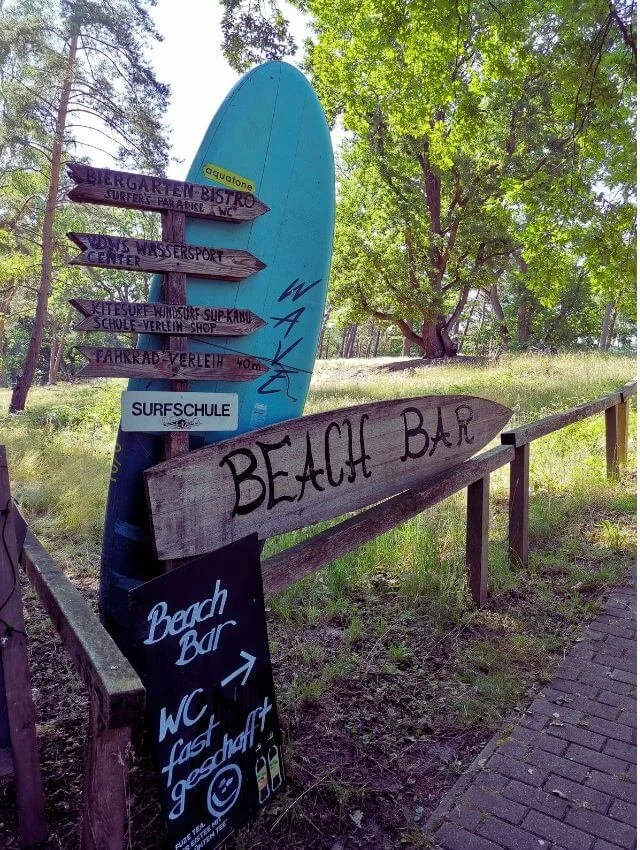 Surfbrett steht an Wegweiser