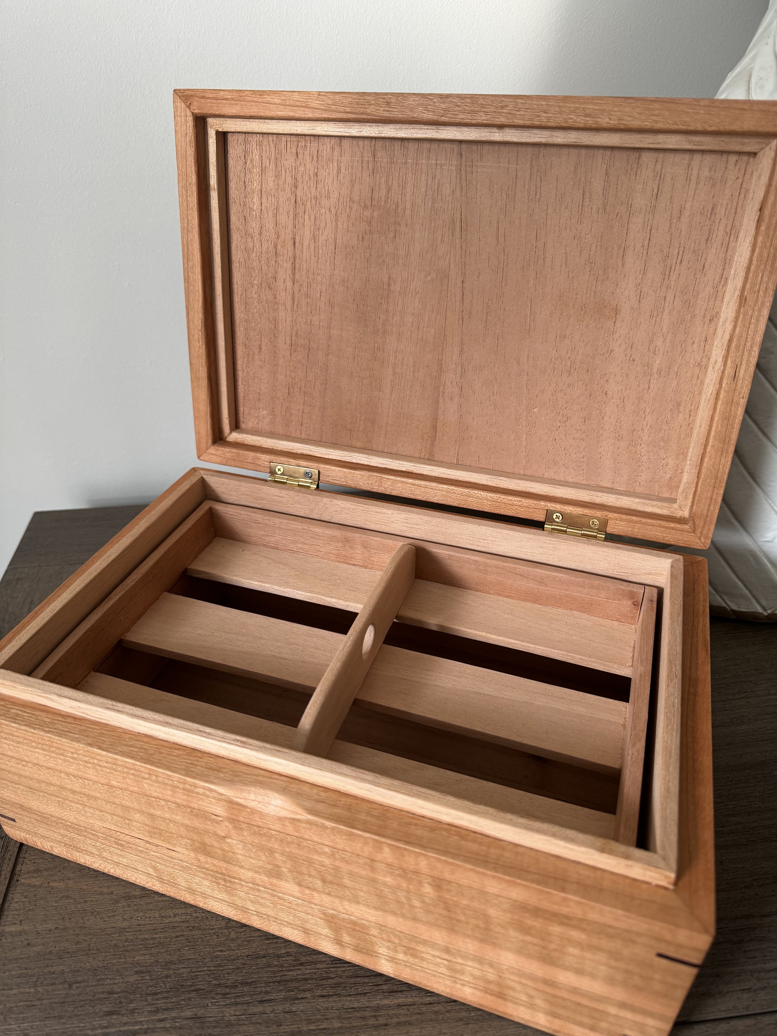 Open cherry and cedar wooden cigar humidor box with compartments inside.