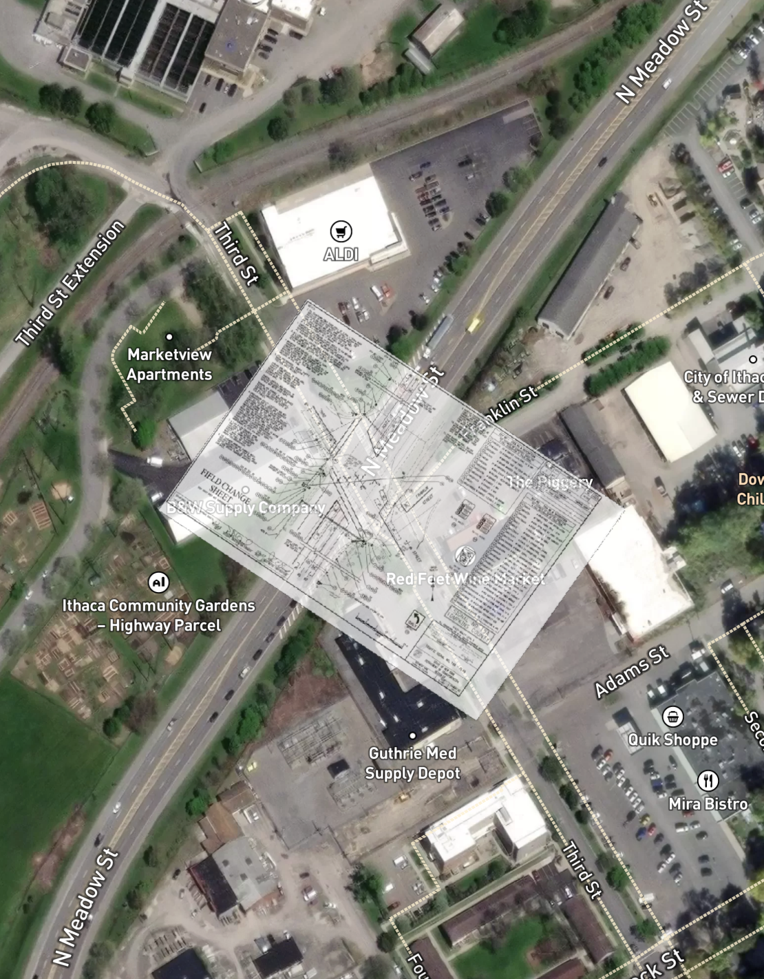 A satellite view of a city area with streets, buildings, parking lots, and green spaces. Notable locations include ALDI, Quik Shoppe, Mira Bistro, Ithaca Community Gardens, BMW Supply, and Red Feet Wine Bar & Kitchen, with labeled streets such as North McCaughlin Street, N Meadow Street, Franklin Street, and Third Street.