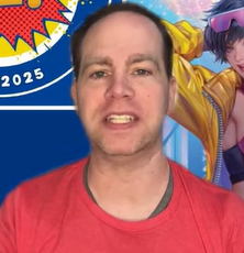 A man with short dark hair and light skin wearing a red shirt, standing in front of a colorful background with cartoon characters.