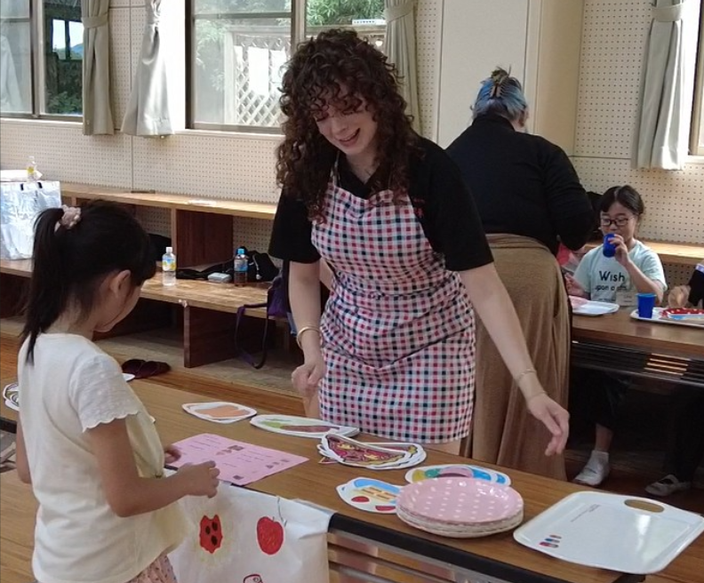 Intern interacting with a Japanese school child in a simulated restaurant.