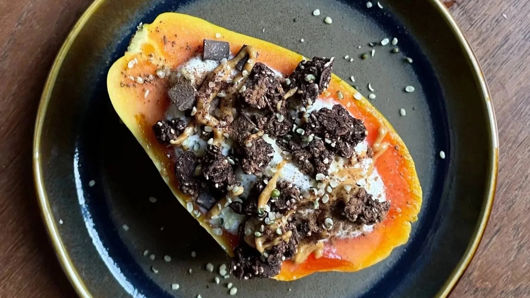 Una fetta di anguria decorata con cioccolato, semi di papavero e un fiocco di panna.
