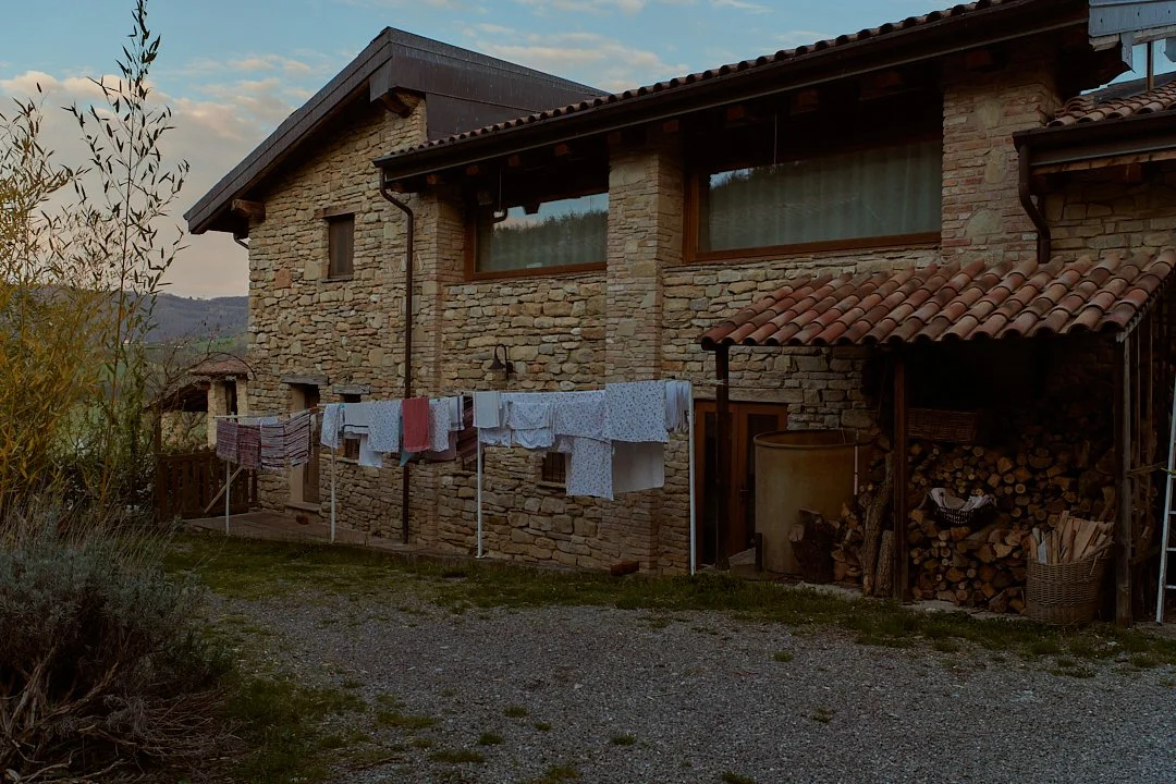 Casa in pietra con tenda per il bucato e legnaia