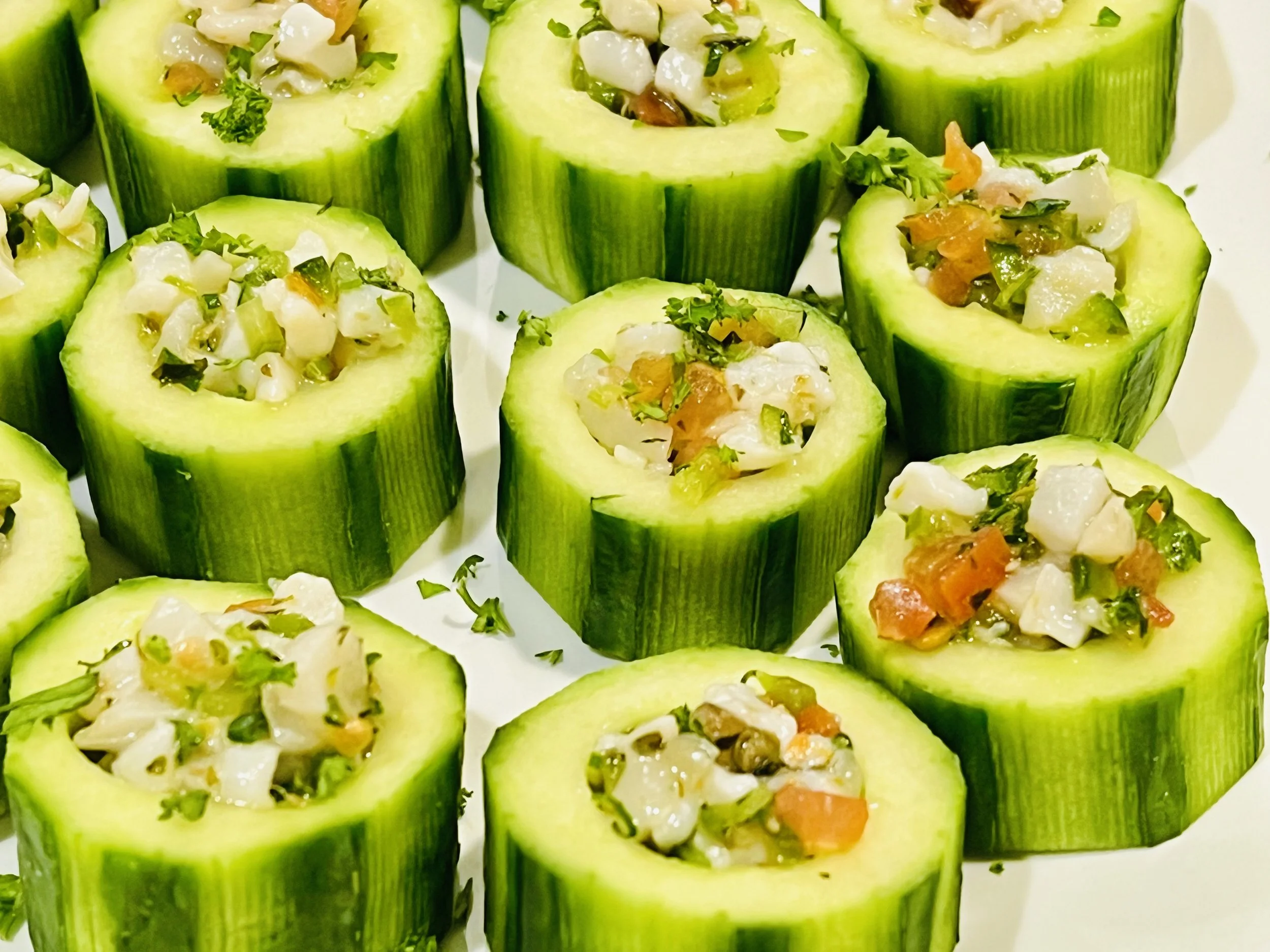 Cucumber rolls filled with a seafood and vegetable mixture, garnished with parsley.