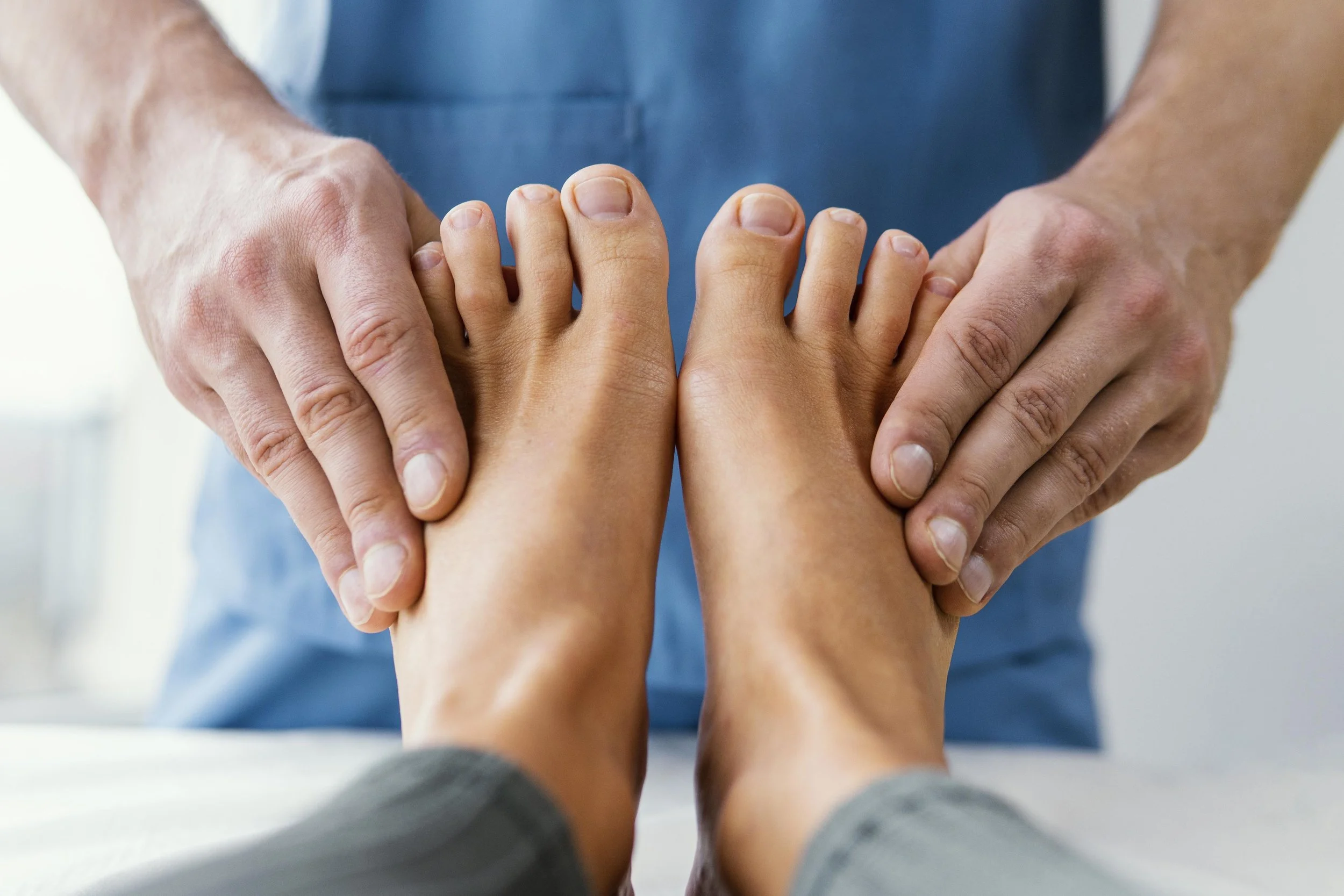 A healthcare professional performing a foot massage or examination on a patient.
