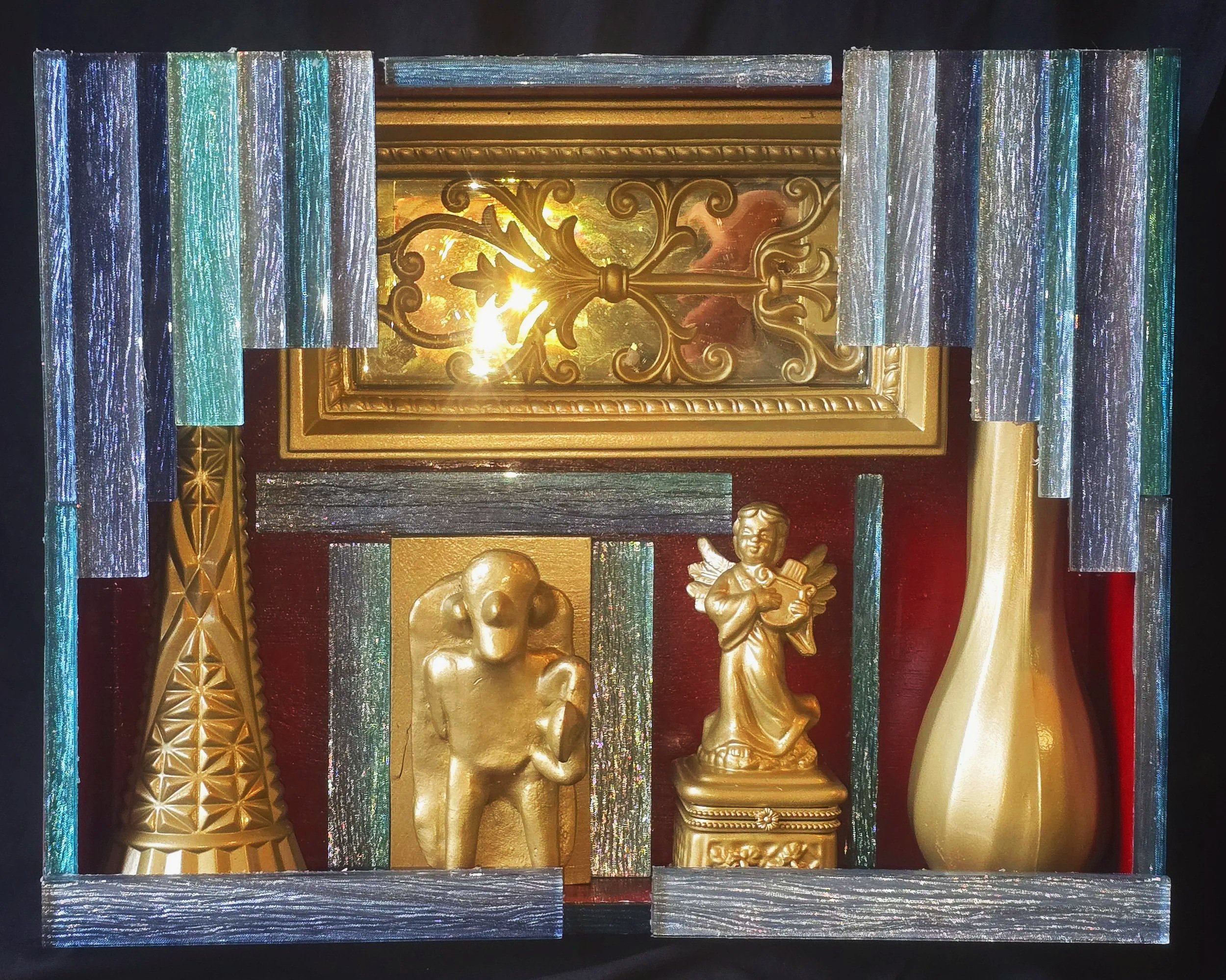 Close-up view of a handmade, hand-painted box containing painted and glued found objects.