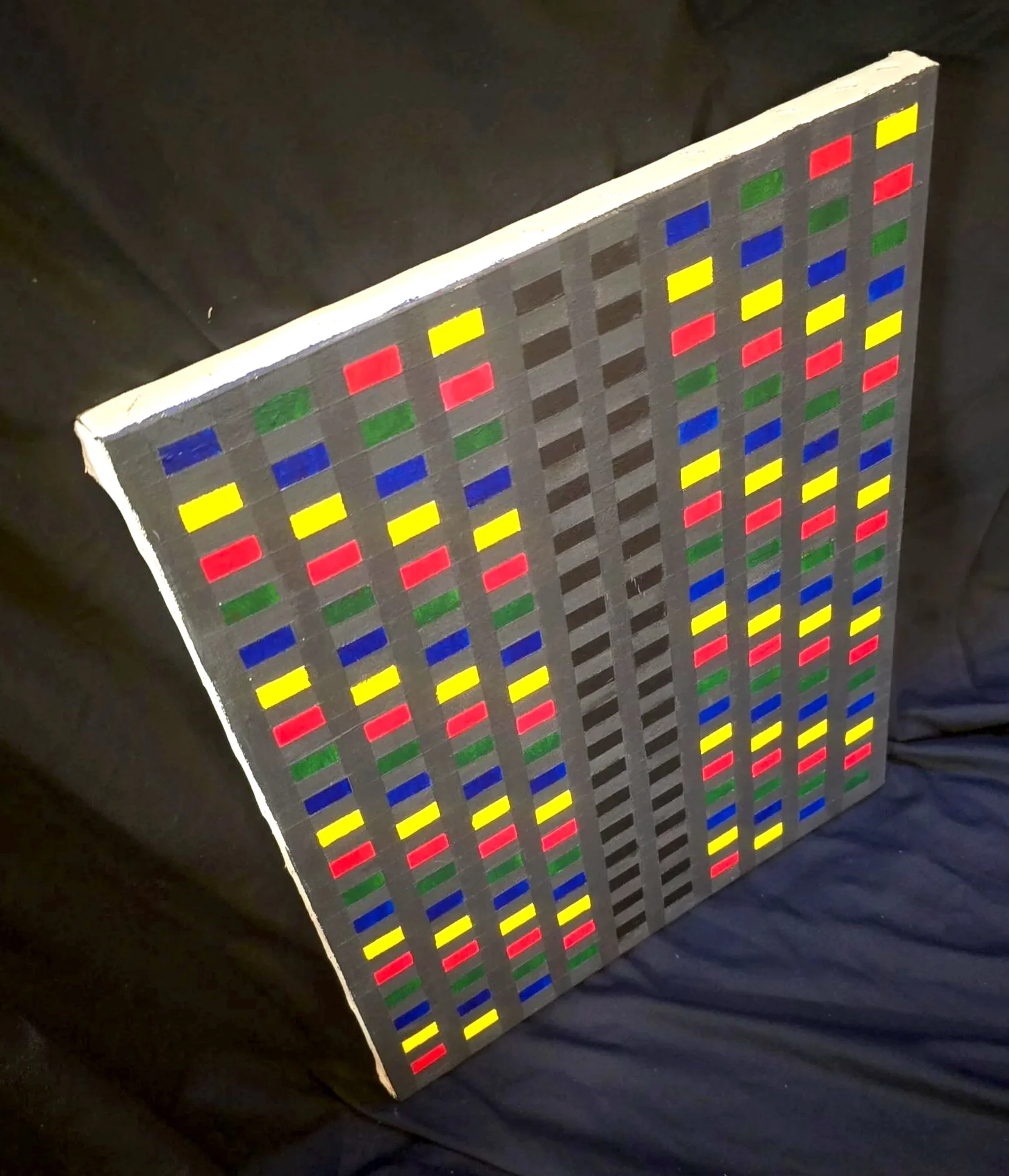Small canvas by Andrew Hall with colorful geometric shapes, photographed casually.