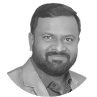 Black and white portrait of a man with short hair and a beard, wearing a suit jacket and dress shirt.