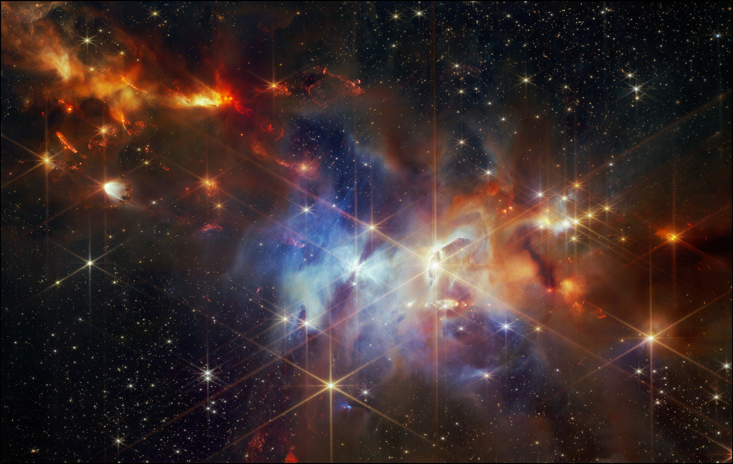 A colorful image of outer space showing stars, clouds of gas and dust, and celestial phenomena with vibrant hues of orange, red, blue, and yellow.