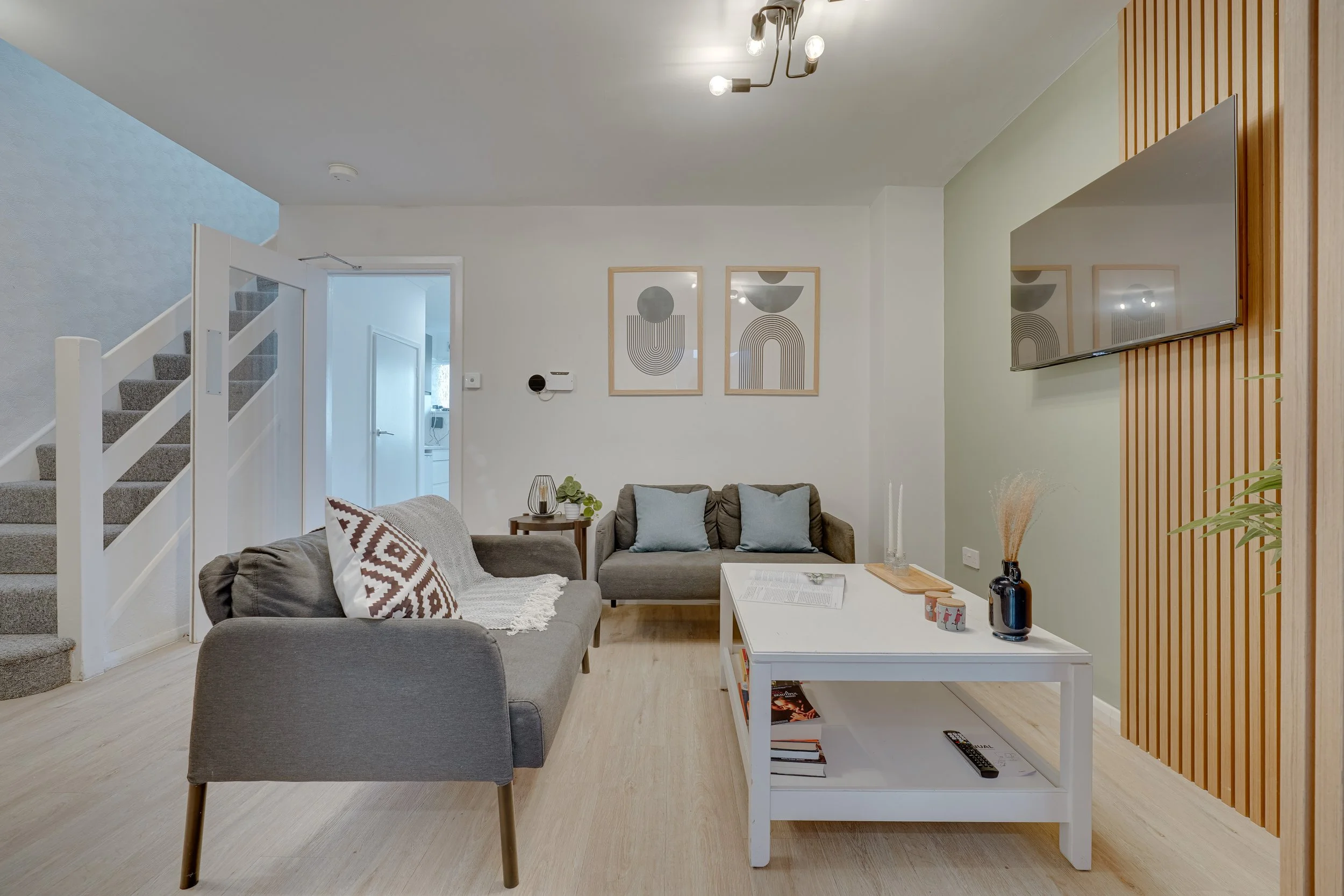Residential living room interior featuring a coordinated seating arrangement, neutral colour palette, feature wall with timber slats, and considered styling creating a calm, modern space.