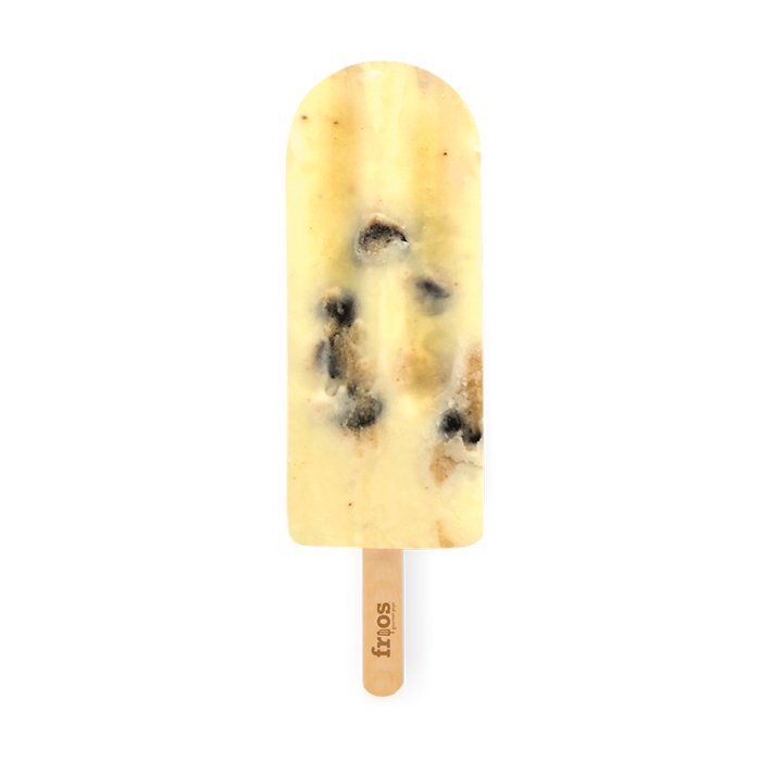 Cream-colored ice cream pop with chocolate cookie pieces on a wooden stick against a white background.