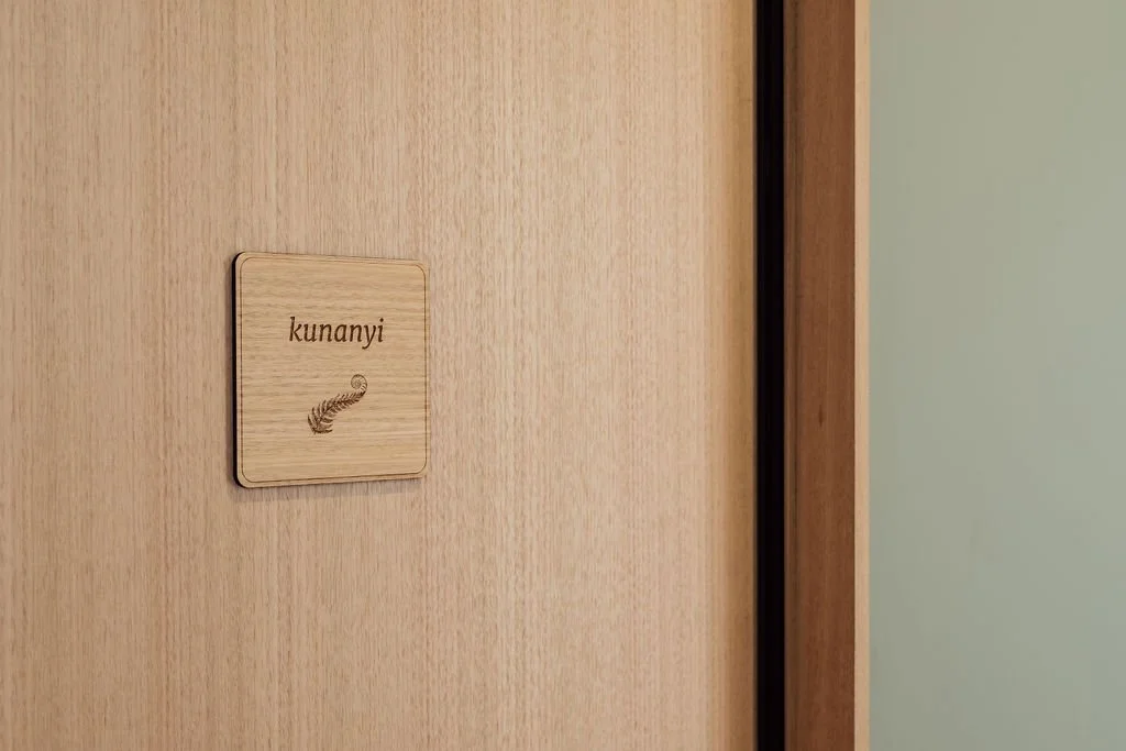 Wooden door with a small sign that reads "kunanyi" and has an arrow pointing to the left.