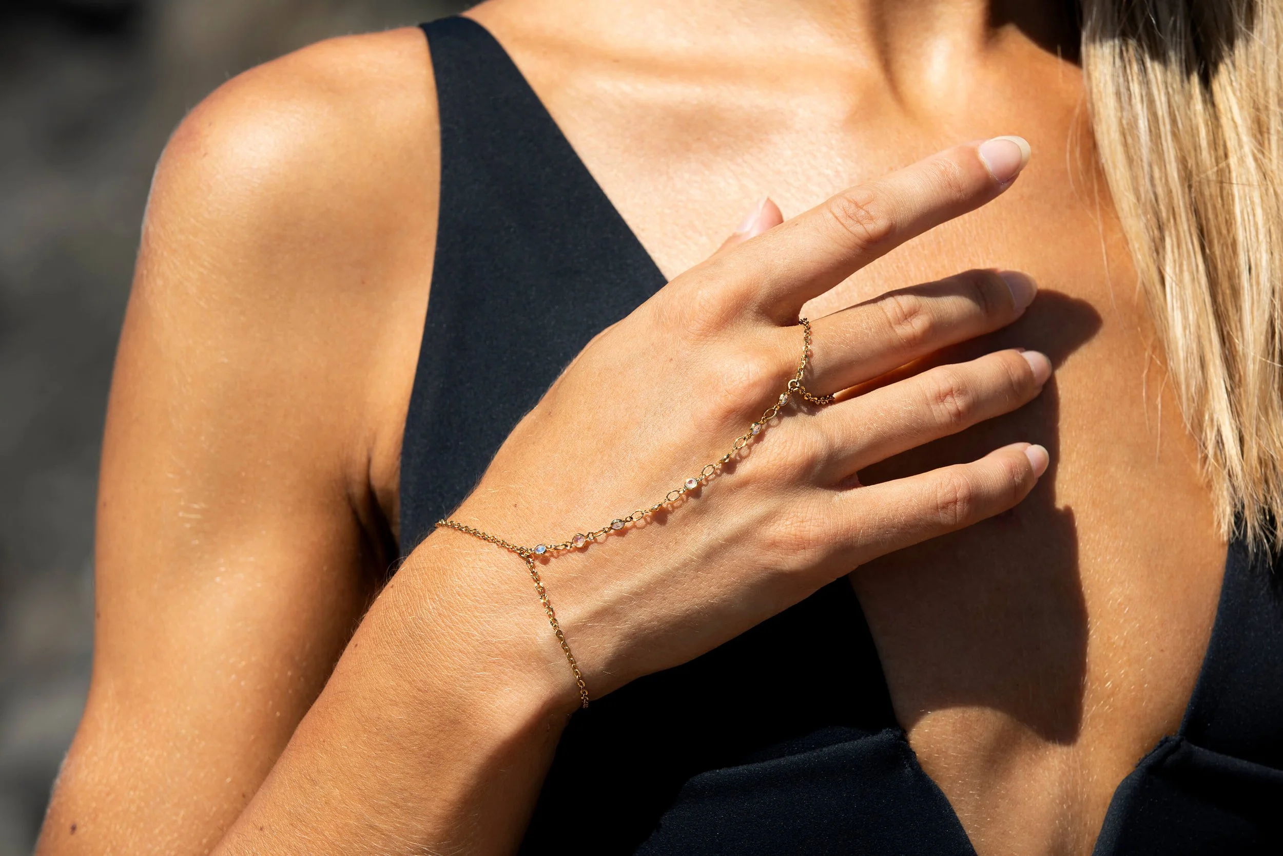 Bijou d'été de mains en or, mettant en valeur des pierres scintillantes.