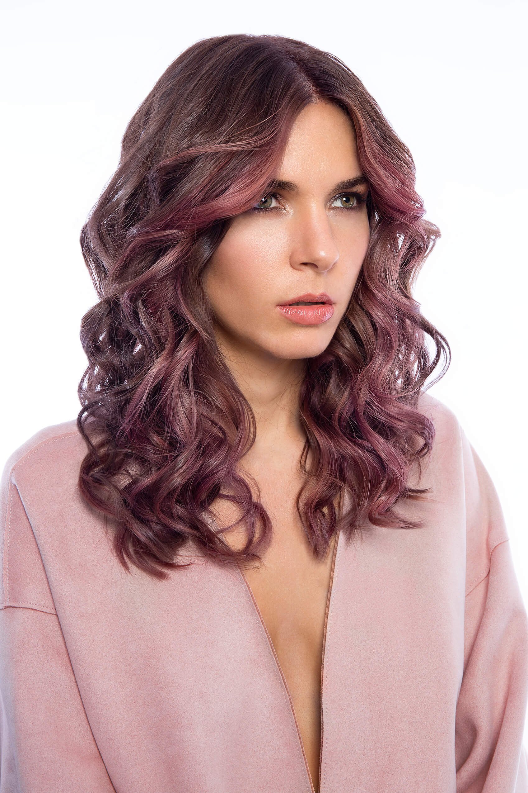 Portrait d'une femme avec des cheveux bouclés et colorés dans des tons rose et violet.
Vue rapprochée d'une coiffure artistique mettant en valeur des couleurs riches et des boucles.
Femme au regard intense avec des cheveux ondulés et une tenue élégan