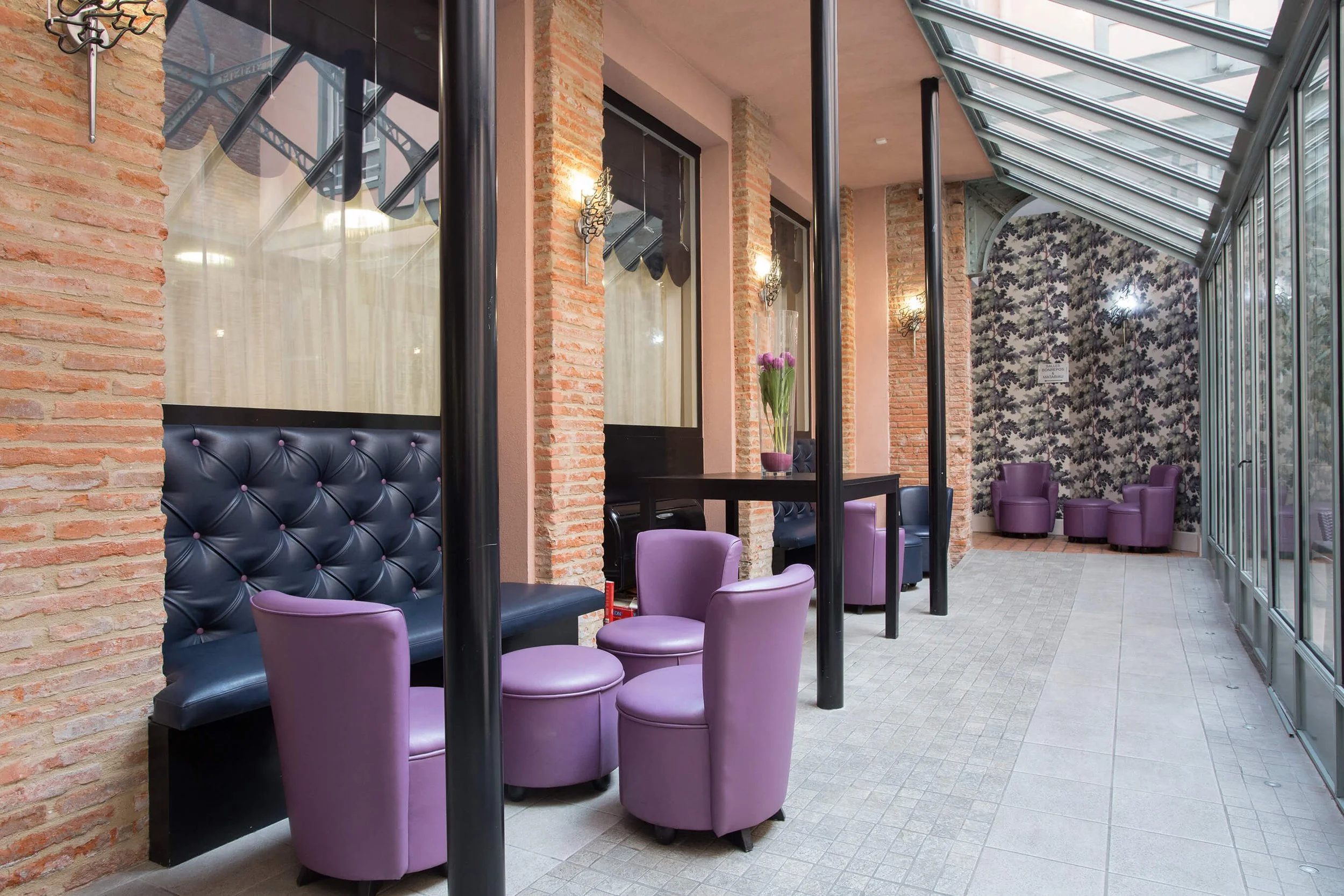 Ce décor moderne, avec ses chaises violettes et ses murs en briques, offre une vue professionnelle et élégante.  L’espace de travail, doté de sièges confortables et d’un éclairage chaleureux, met en avant le mobilier et l’esthétique contemporaine.  L