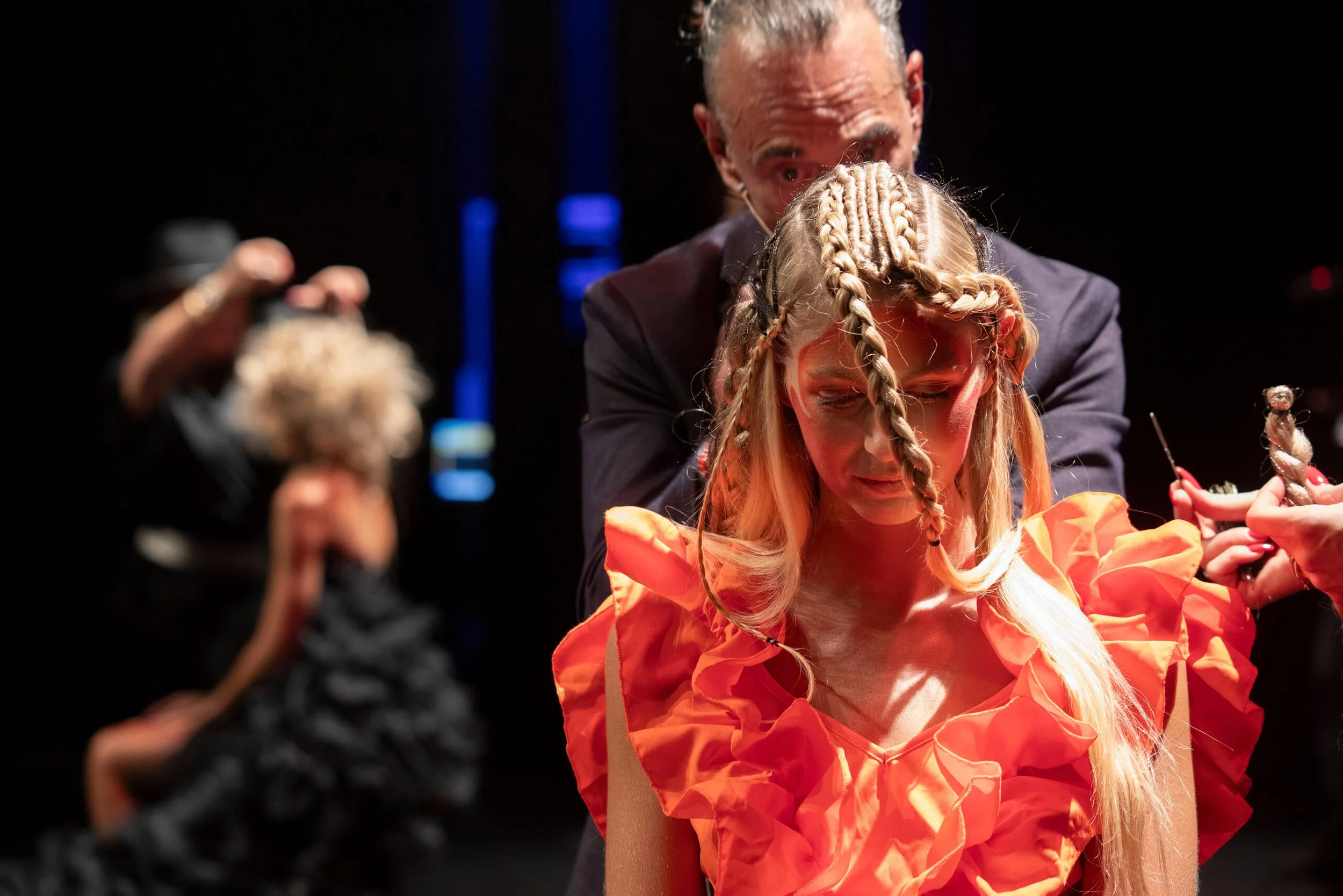 Un photographe professionnel capturant l'art de la coiffure avec des tresses créatives et une robe orange.