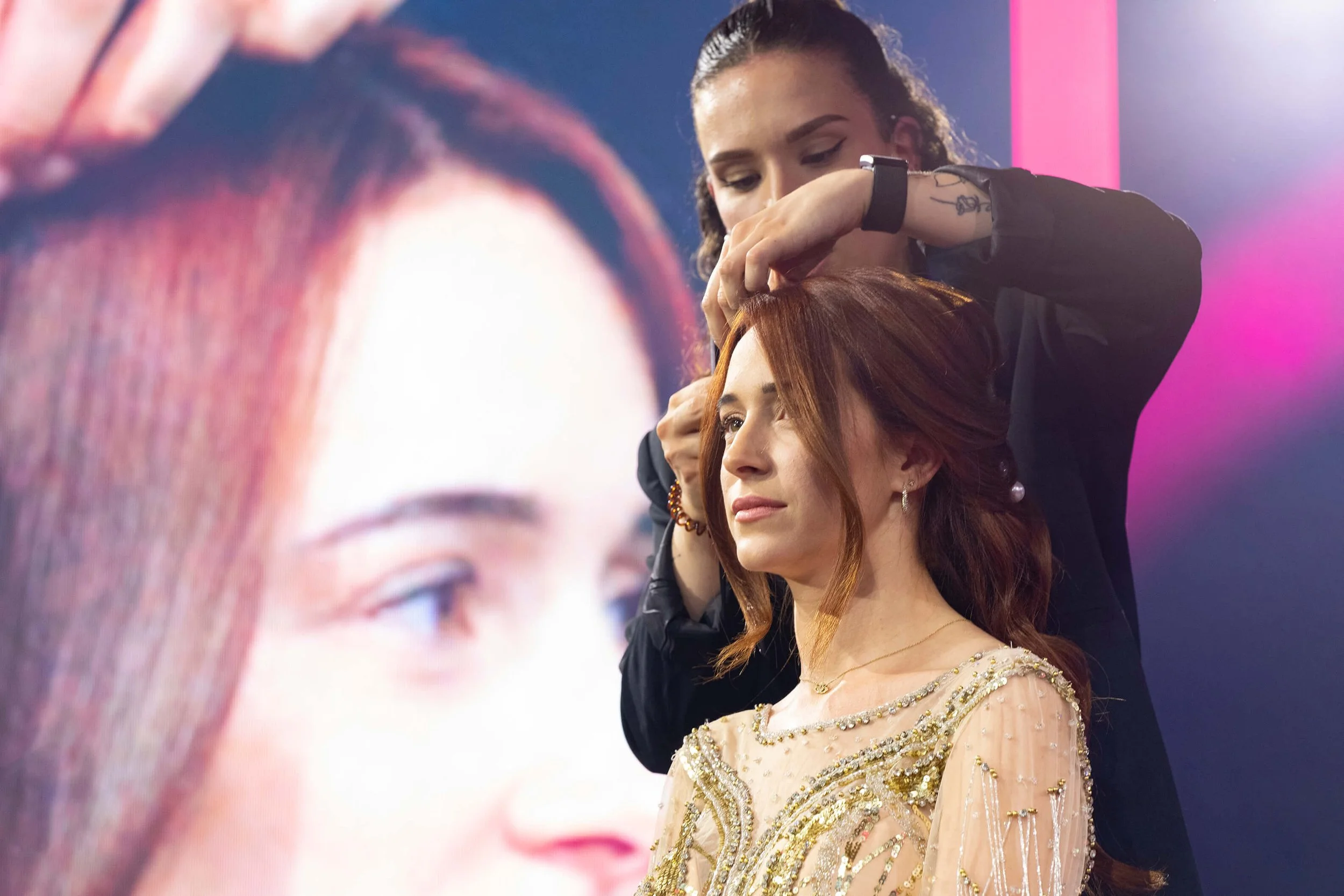 Une photographe professionnelle en action, montrant l'interaction entre le coiffeur et le modèle.