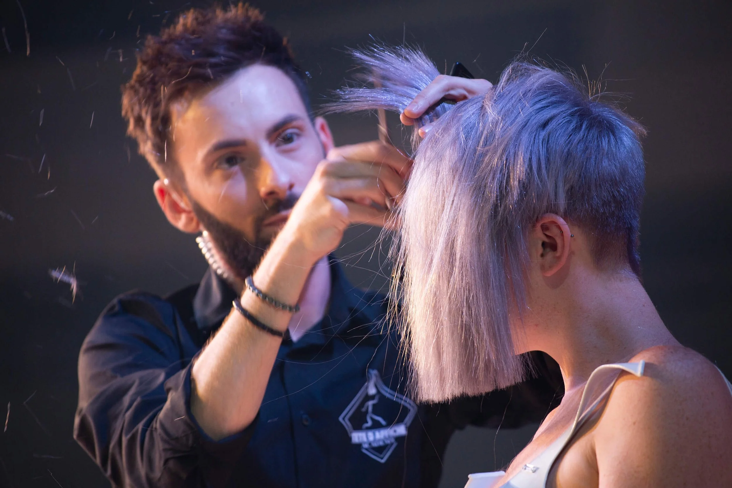 Un photographe professionnel capturant l'art de la coiffure avec des couleurs de cheveux modernes.
Un coiffeur en train de créer une coiffure unique sur un modèle avec des cheveux teints.
Détails d'une coupe de cheveux réalisée par un professionnel d