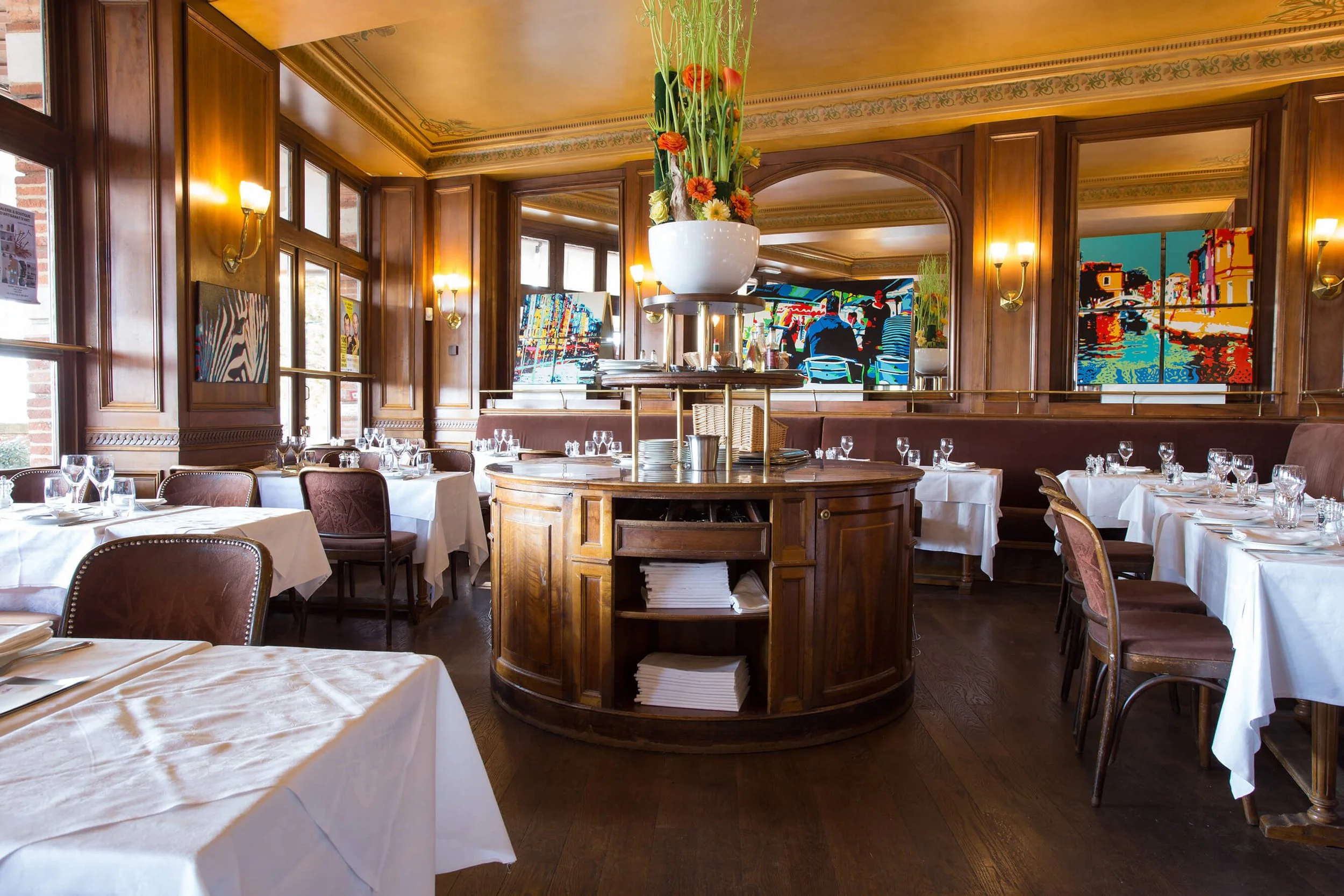Intérieur d’un restaurant élégant, décoré par François Fauré, avec des tables sophistiquées et une ambiance chaleureuse.