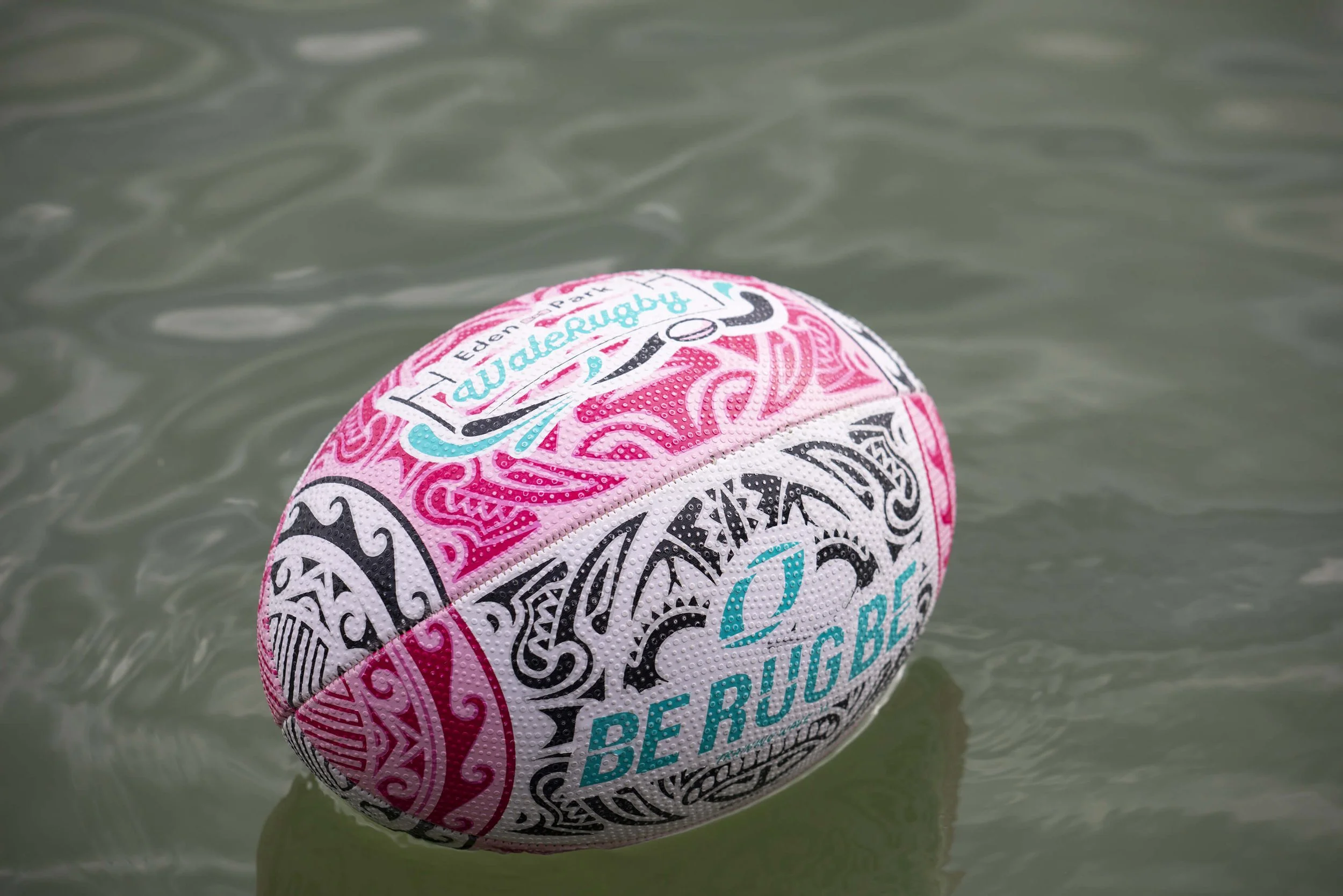 Un ballon de rugby coloré flottant sur l’eau, immortalisé par le photographe François Fauré.