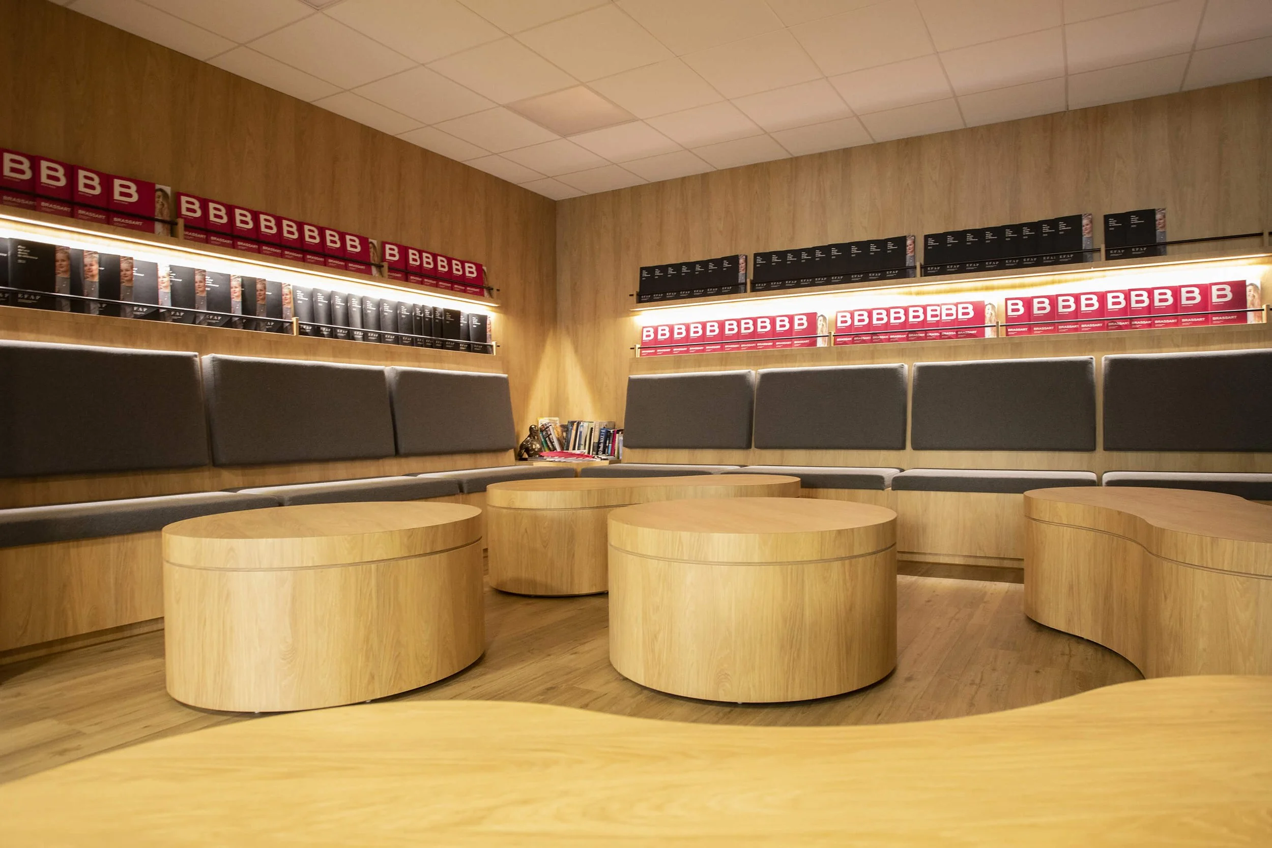 Décor professionnel photographié par François Fauré, mettant en avant des couleurs chaleureuses et des objets en bois. Style photographique de François Fauré, illustrant un espace moderne avec des éléments en bois et des assises confortables. Décor d