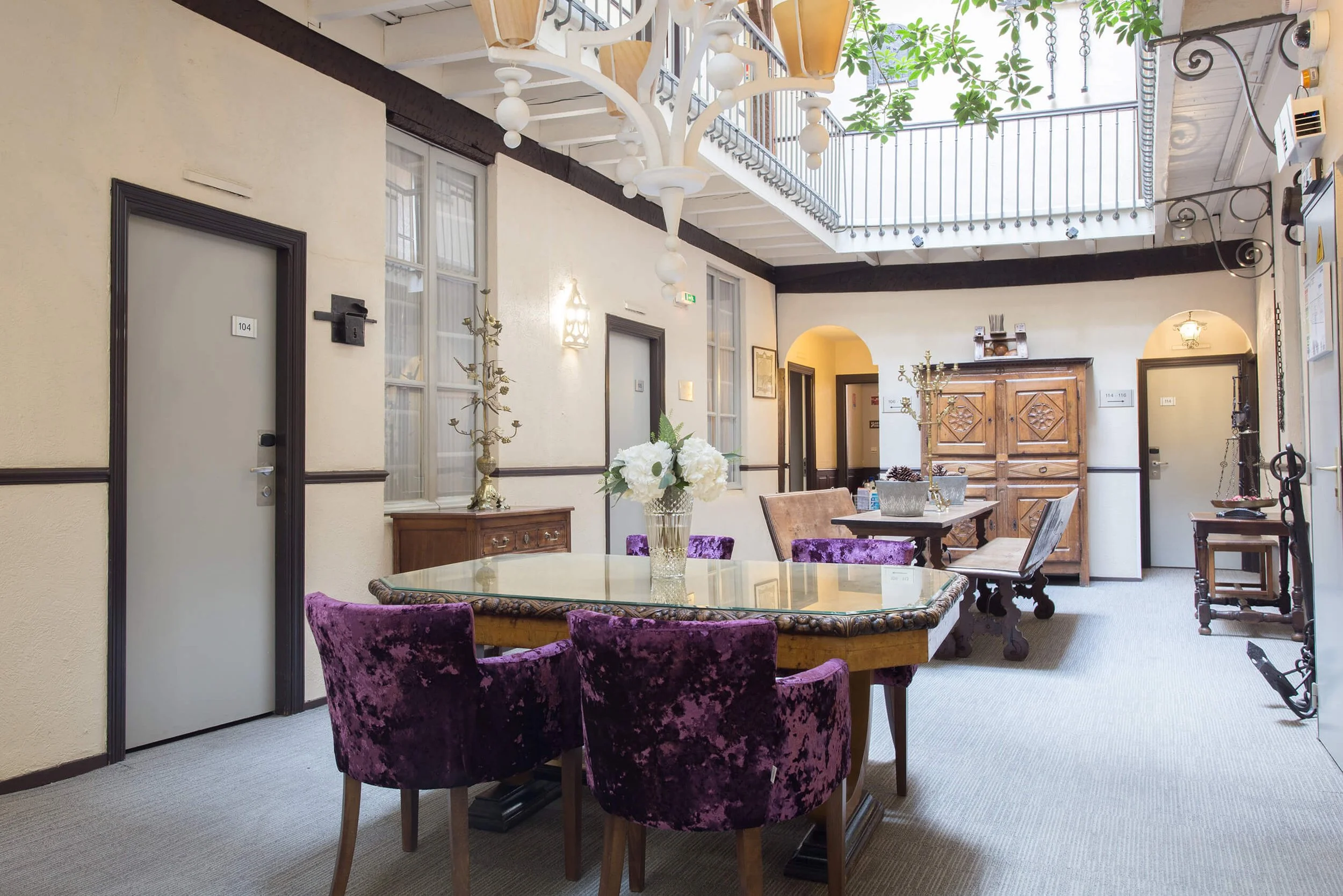 Intérieur professionnel élégant avec des chaises violettes et un décor raffiné.  Photographie de François Fauré, ce décor intérieur mêle vintage et modernité.  L’espace de travail d’entreprise se distingue par une table en verre et des objets décorat