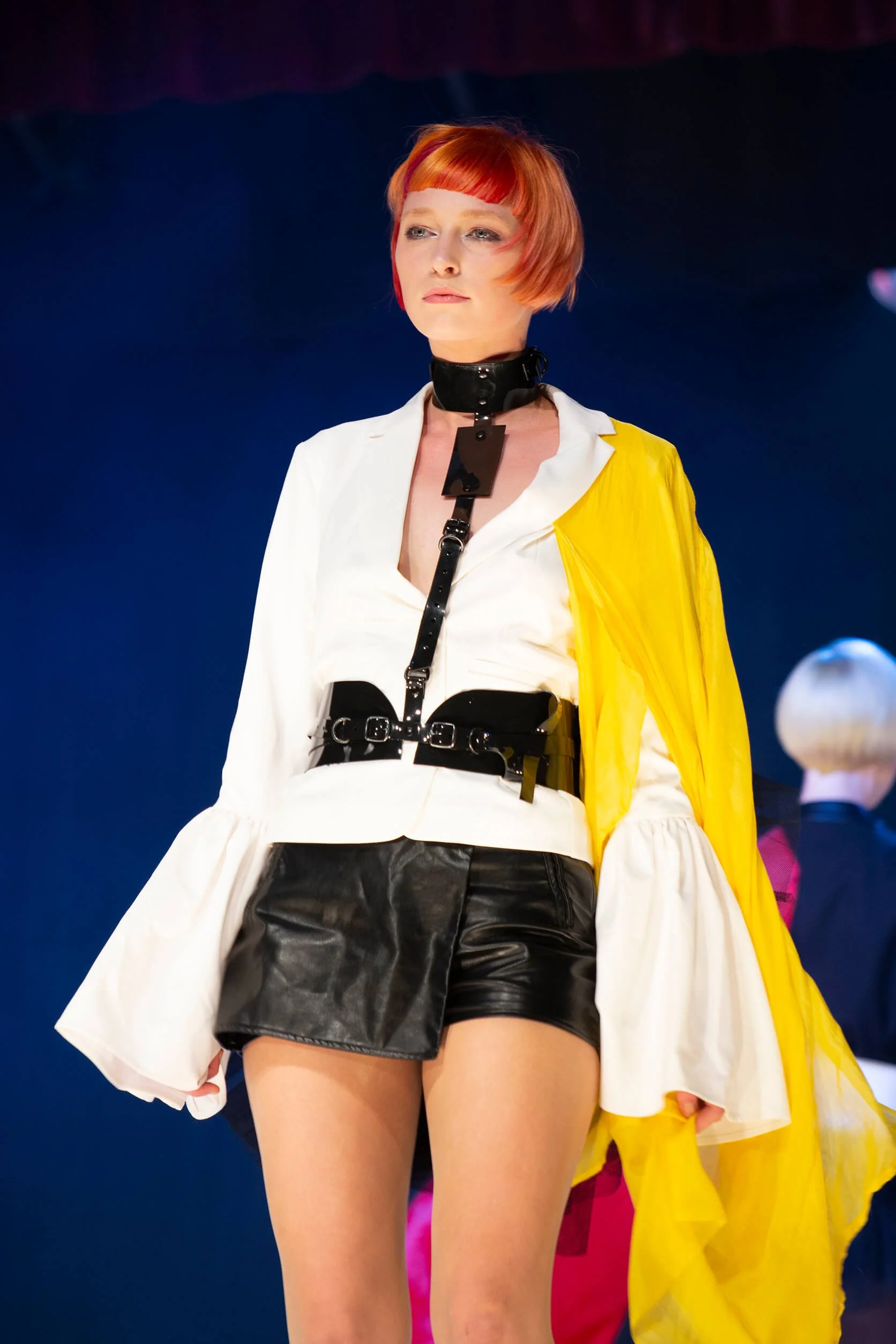 Vue d'un modèle avec une coiffure artistique et des vêtements colorés.
Photographie professionnelle mettant en avant des couleurs de cheveux vives et un style contemporain.
Modèle sur scène avec une coiffure audacieuse et un décor vibrant.
Détails d'