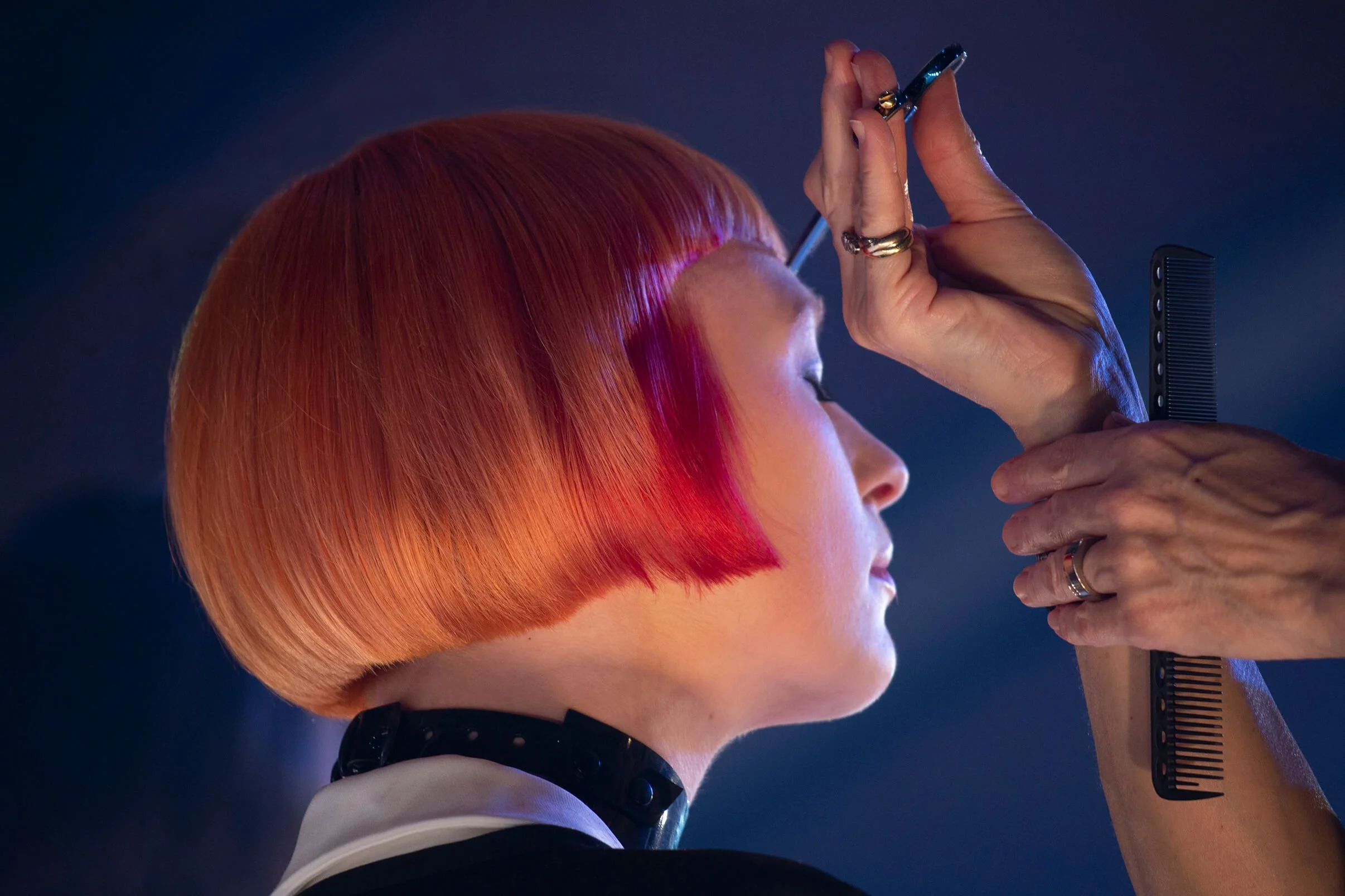 Coiffure aux couleurs vives, mettant en avant une coupe bob et des reflets rouges.