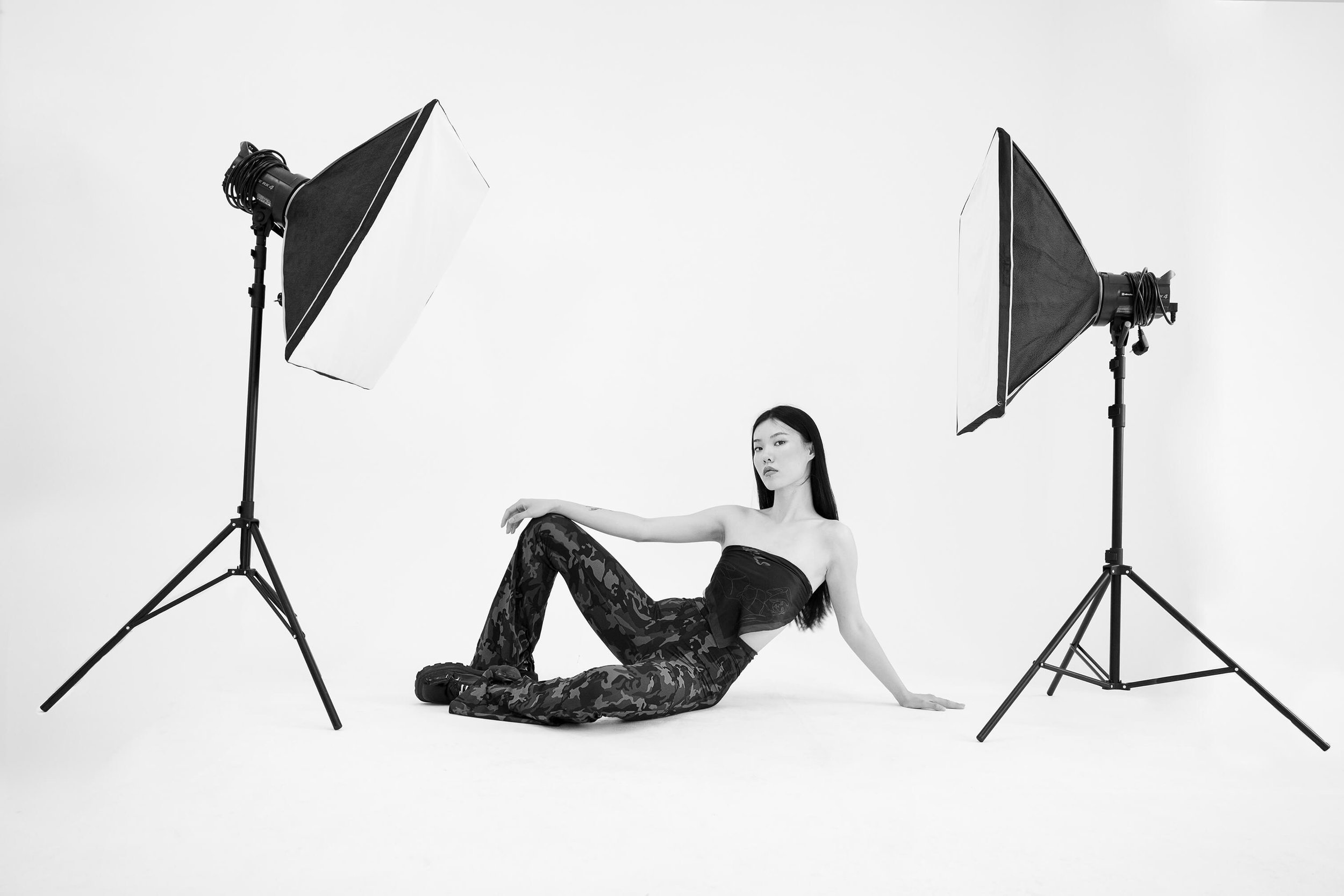 Une femme poser dans un studio photo avec deux grands softboxes d'éclairage