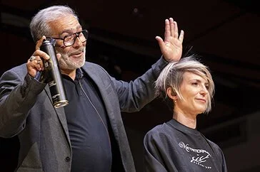 Photographe professionnel présentant l'art de la coiffure avec un modèle.
Style photographique mettant en avant les couleurs de cheveux et le décor.
Présentation d'une coiffure moderne par un expert en coiffure.
Décor élégant pour une démonstration d