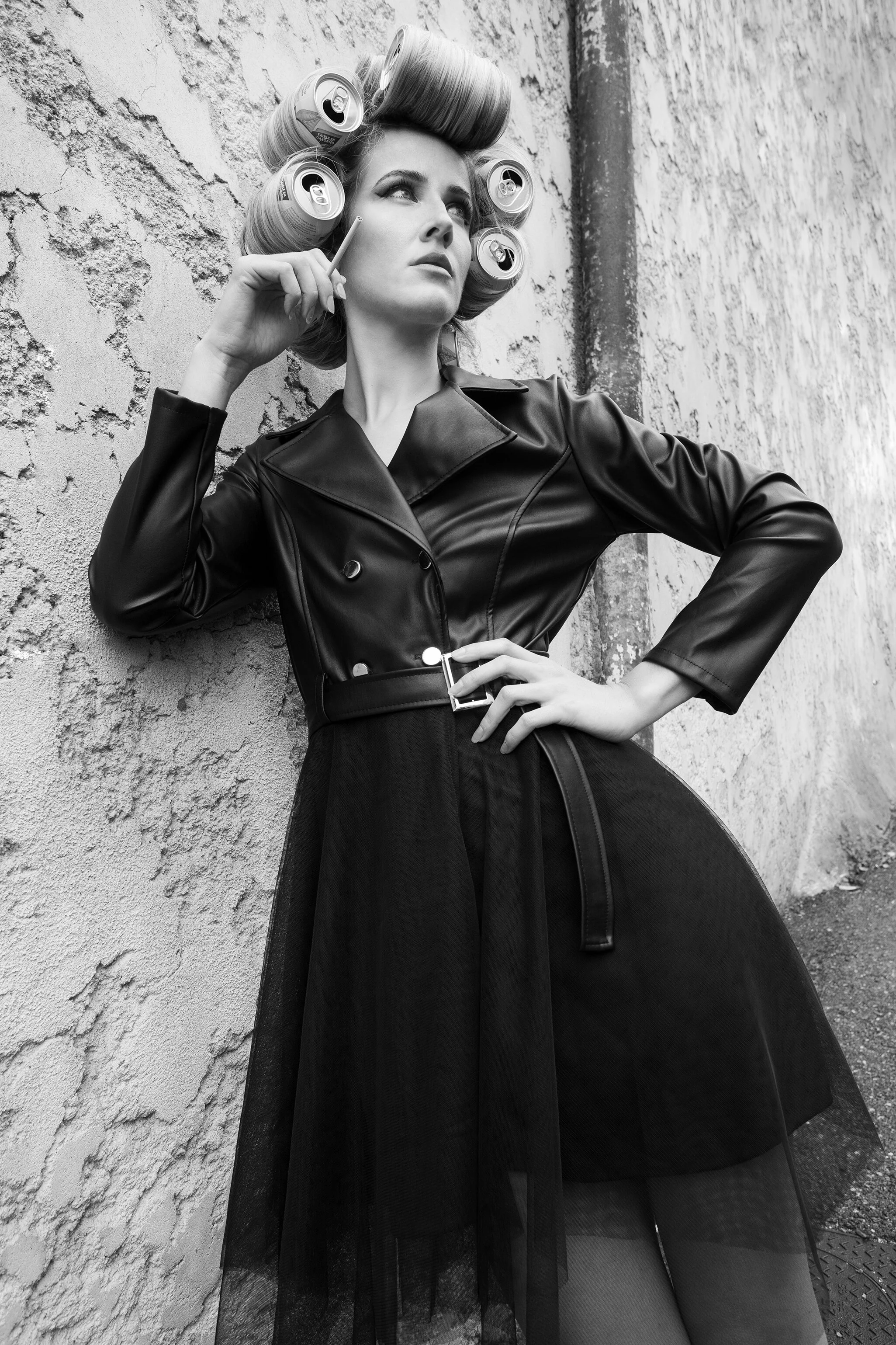 Photographie artistique de coiffure avec une femme en tenue élégante et des rouleaux de cheveux.
Point de vue d'un photographe professionnel sur l'art de la coiffure dans un décor stylisé.
Coiffure moderne en noir et blanc avec des éléments de mode e