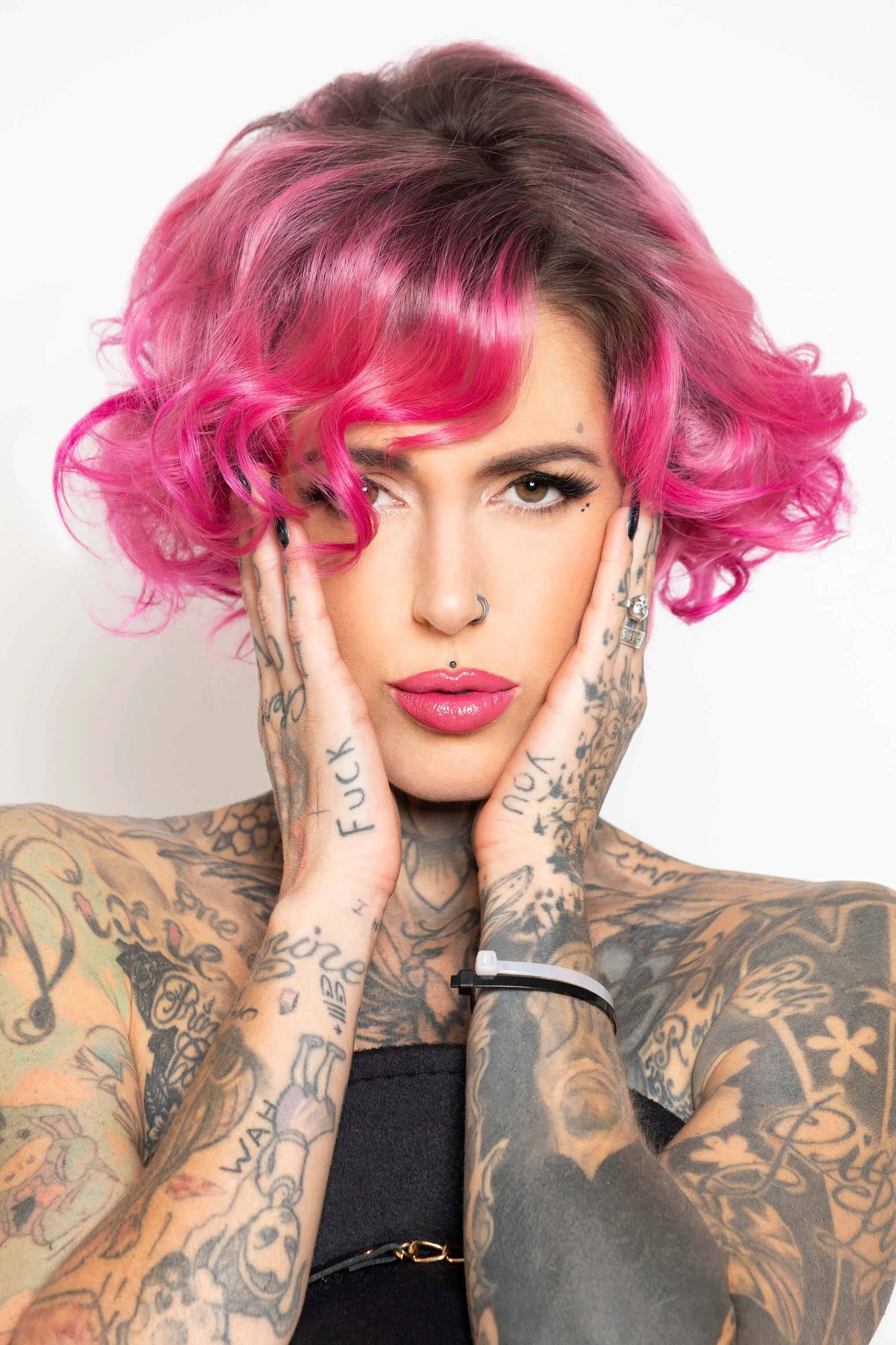 Un modèle avec des tatouages et une coiffure colorée, illustrant le style unique de la photographie de coiffure.