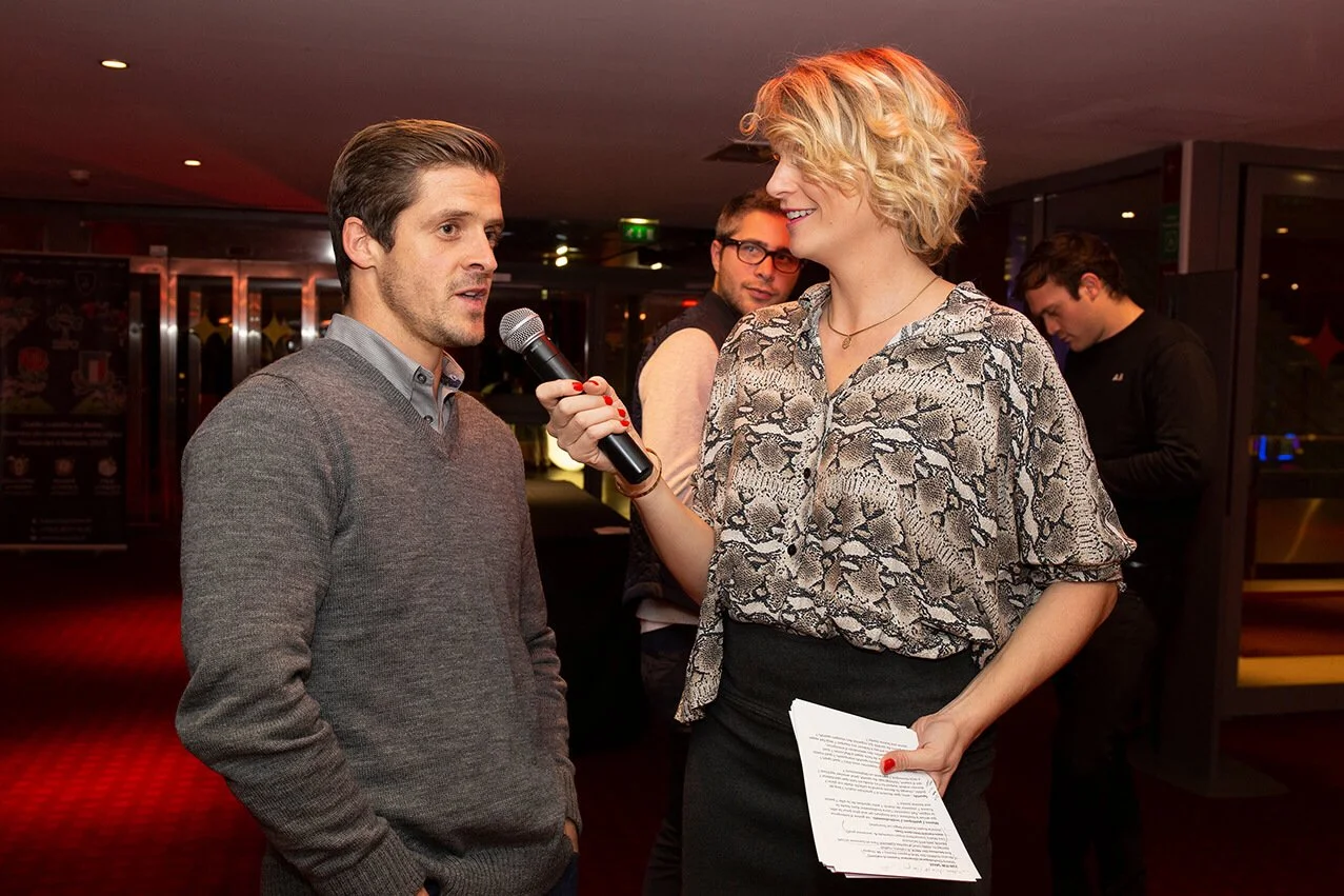 Lors d’un événement, le photographe professionnel François Fauré a capturé un moment d’interview, mettant en valeur le décor et les couleurs vives.