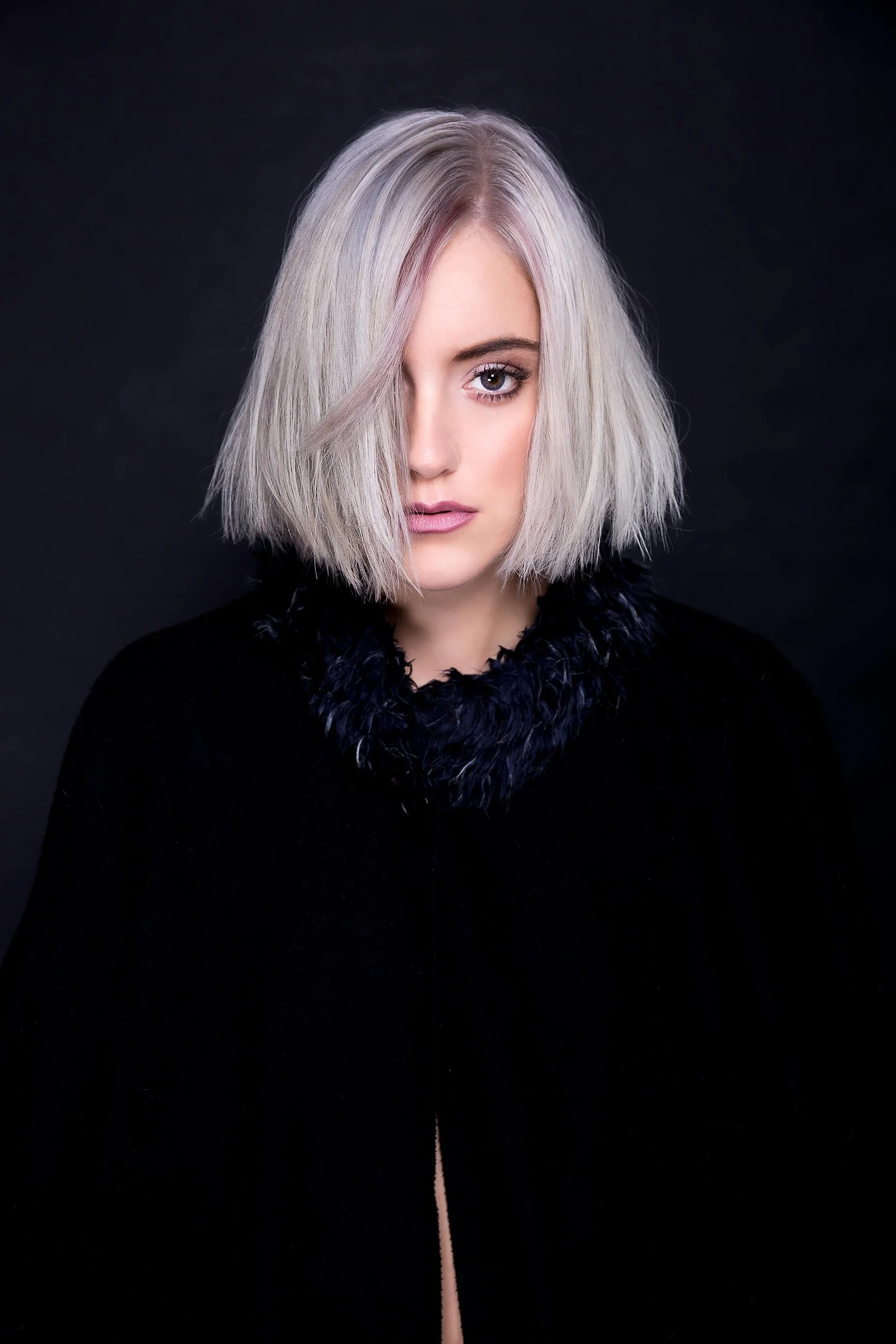 Vue artistique d'un modèle avec cheveux blonds platine sur fond noir.
Portrait d'une femme avec une coiffure moderne et élégante.
Coiffure contemporaine en noir et blanc avec décor minimaliste.
Photographie créative mettant en valeur la texture des c